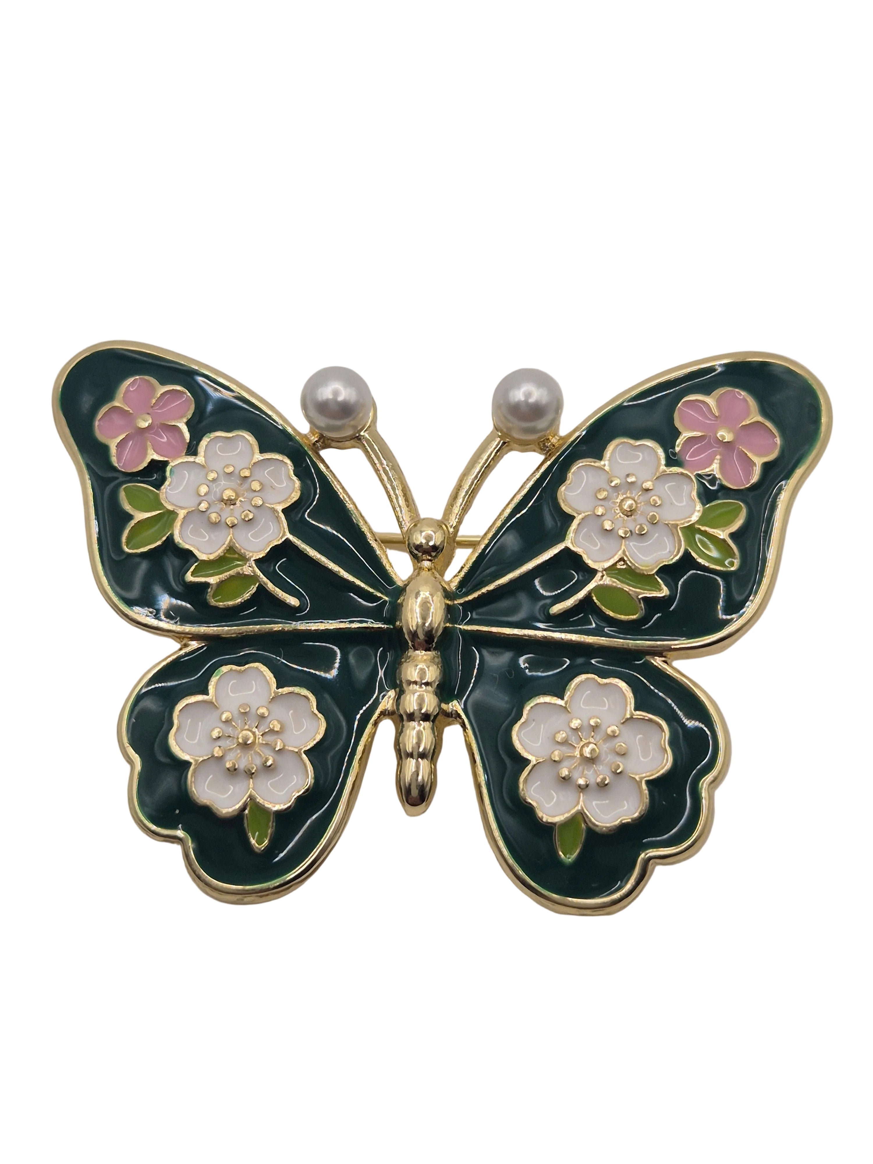 Butterfly brooch with floral details on a white background
