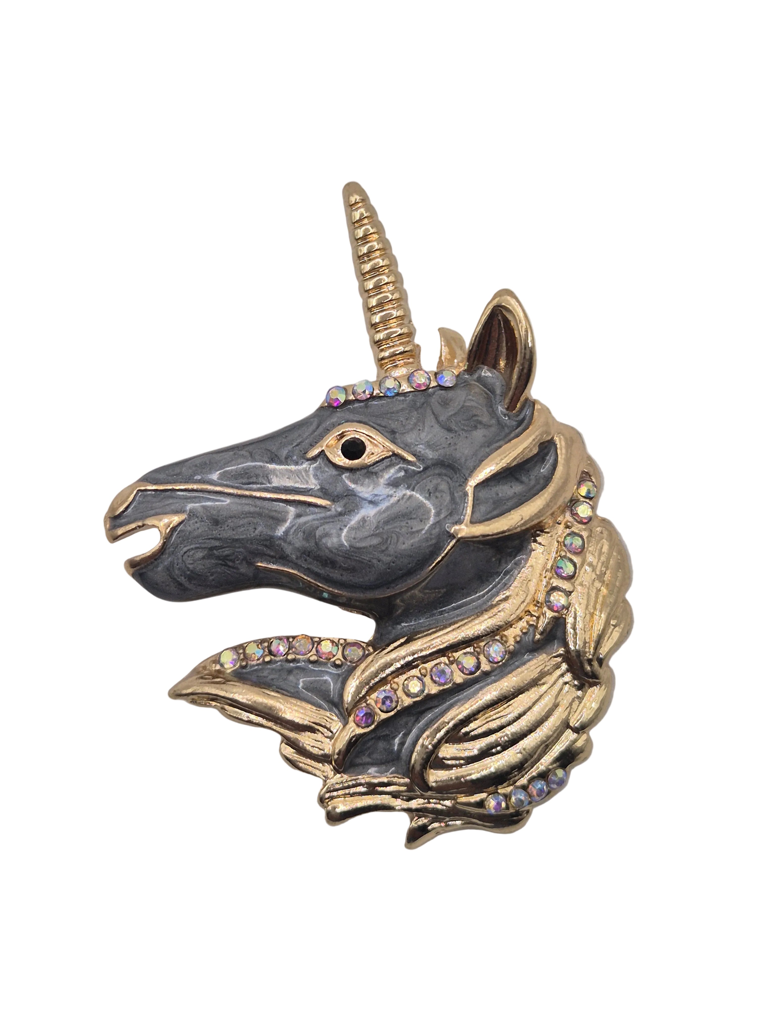 Unicorn head brooch with gold and gray colors on a white background