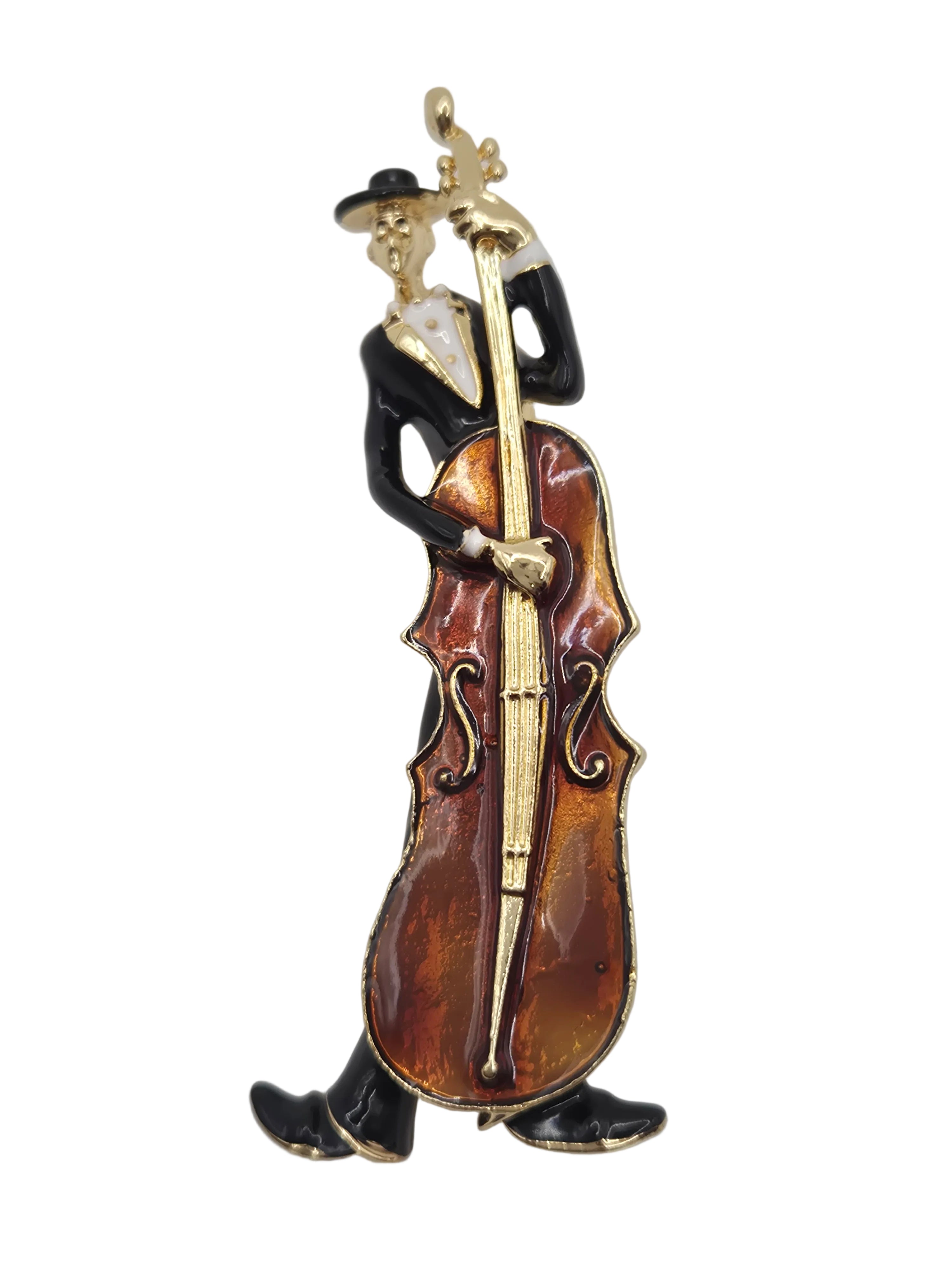 Violin-shaped brooch with gold accents on a gray background