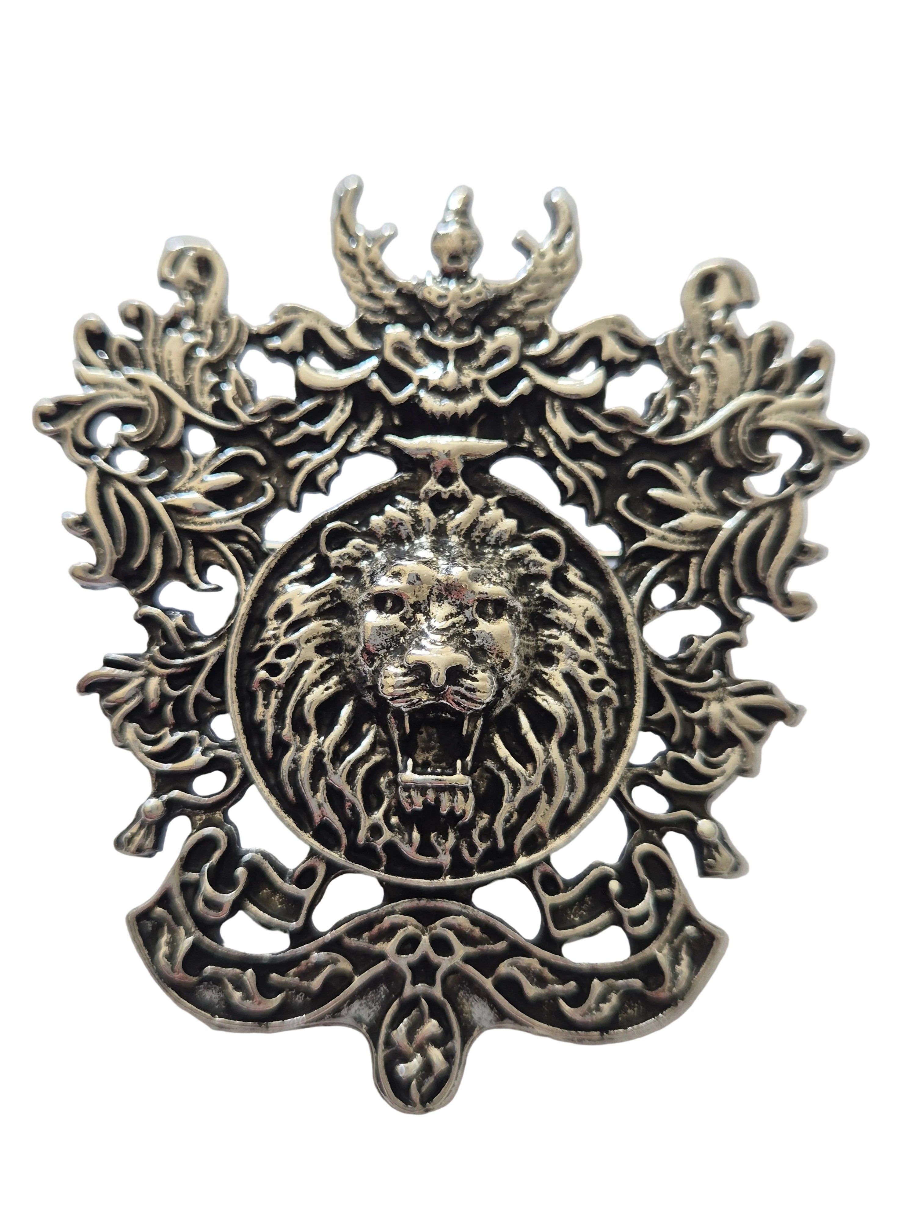 Metal brooch lion's head design on a white background
