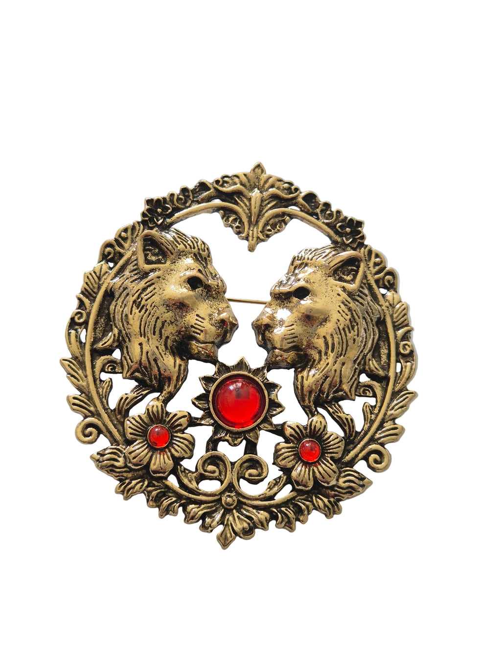 Decorative lion brooch with two animals and red gemstones on a light gray background