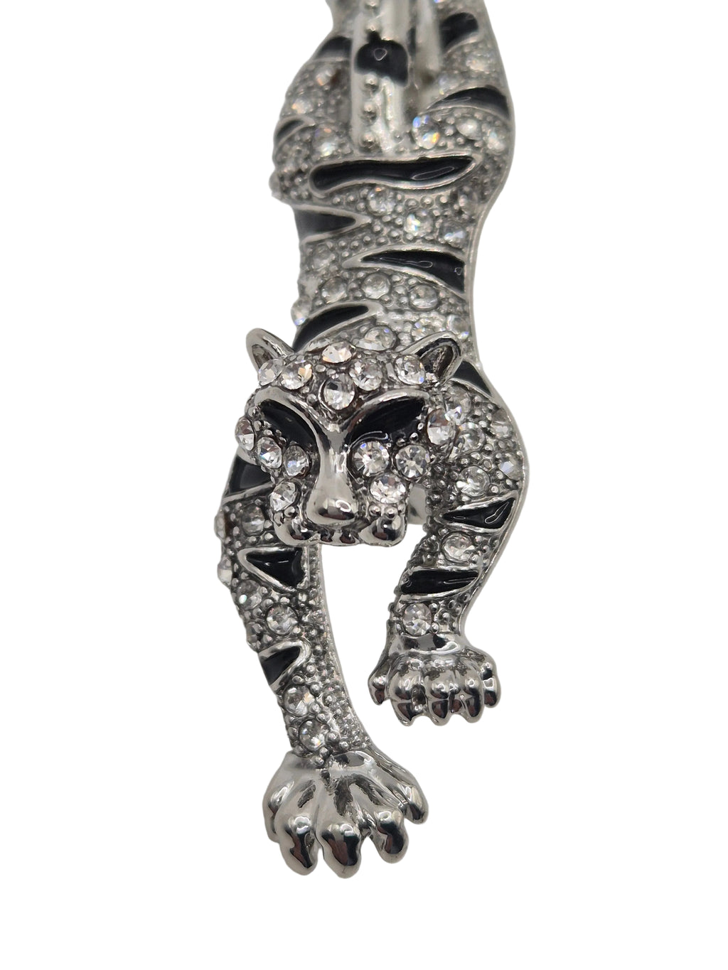 Silver tiger brooch with gemstones on a white background