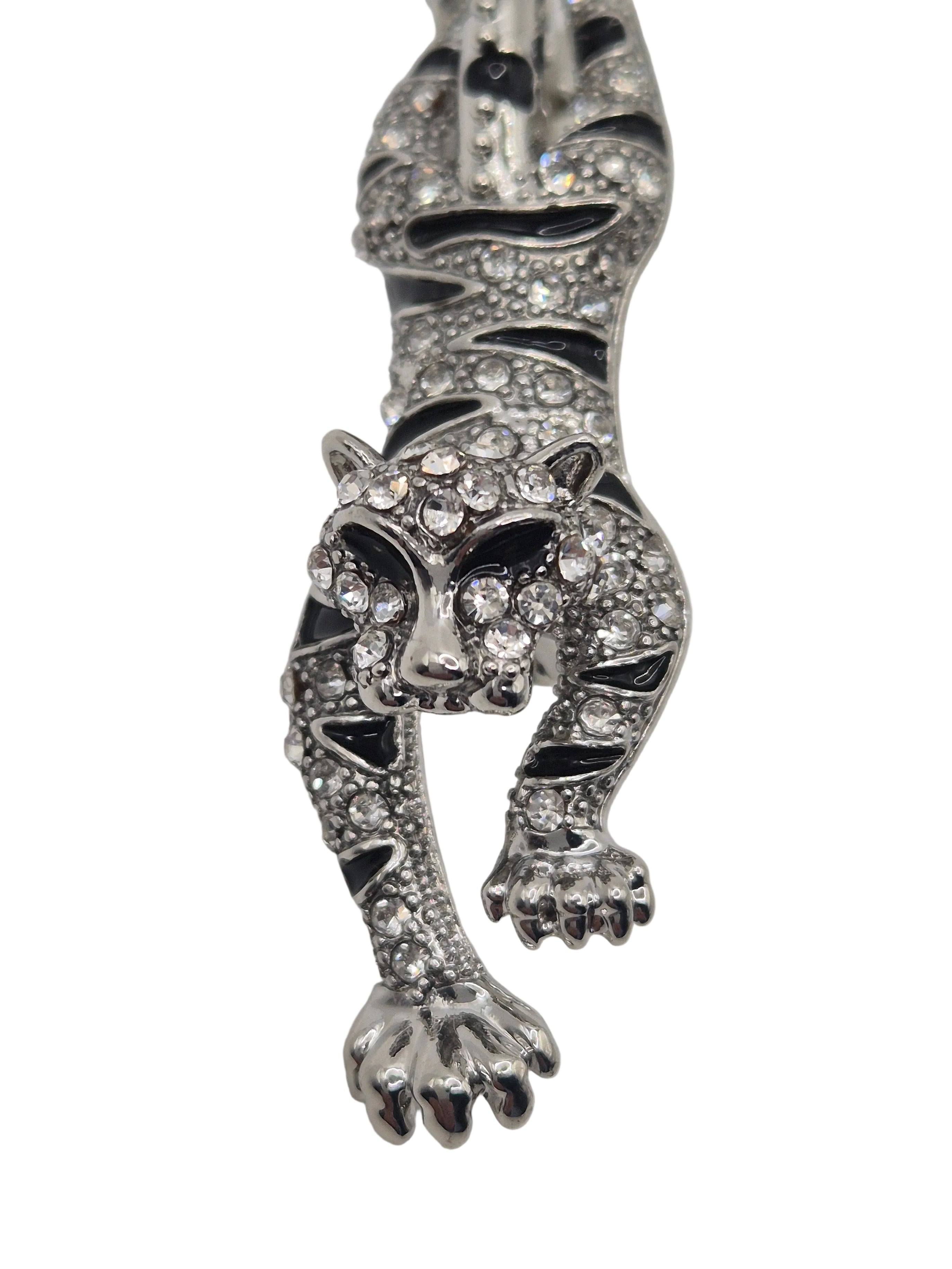 Silver tiger brooch with gemstones on a white background