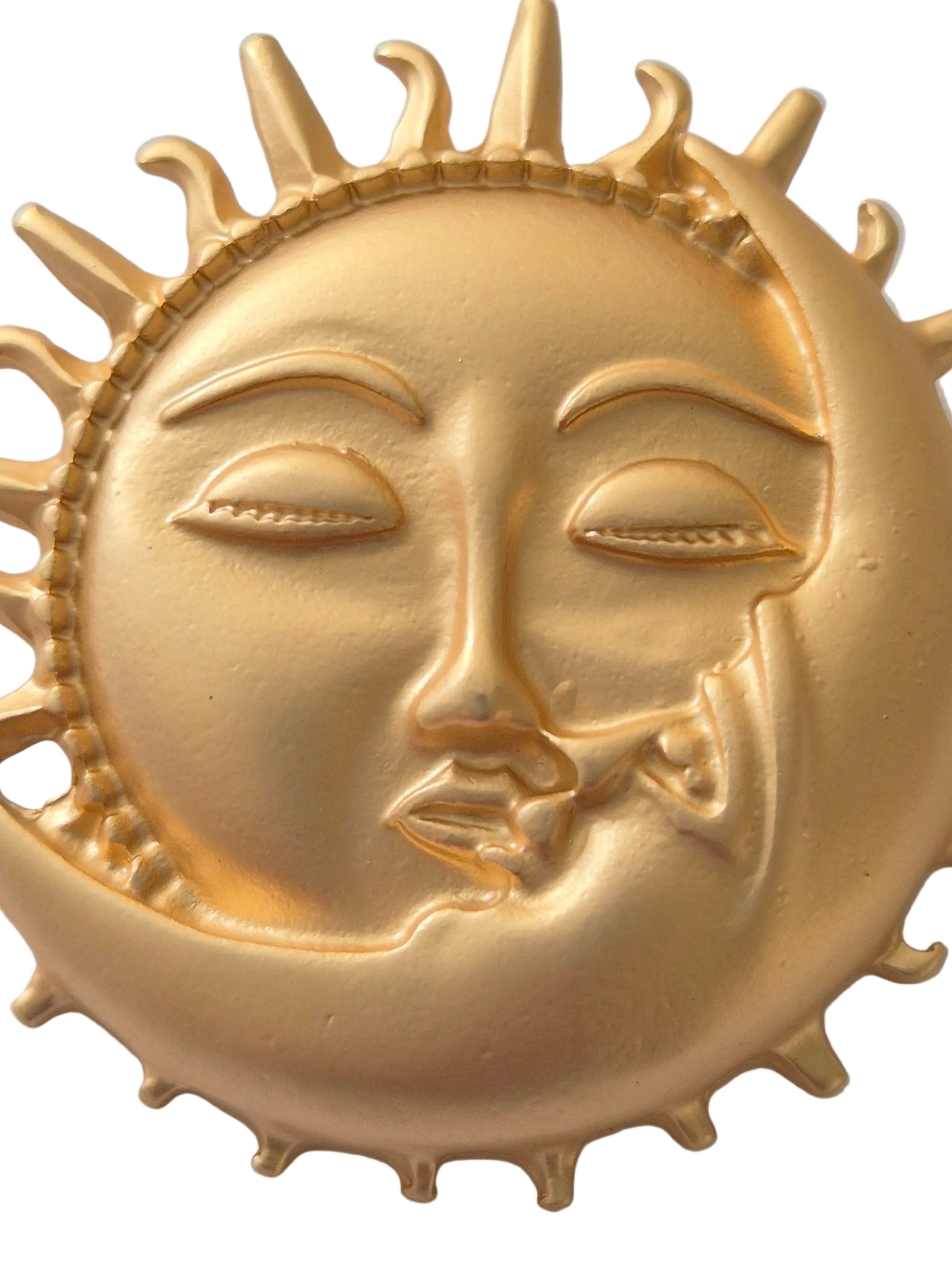 Decorative gold sun and moon face brooch on a white background
