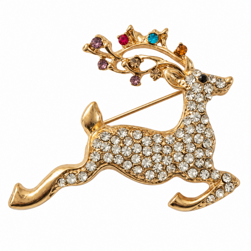 A gold reindeer brooch embellished with clear rhinestones, featuring antlers decorated with multicolored gemstones, set against a plain white background.
