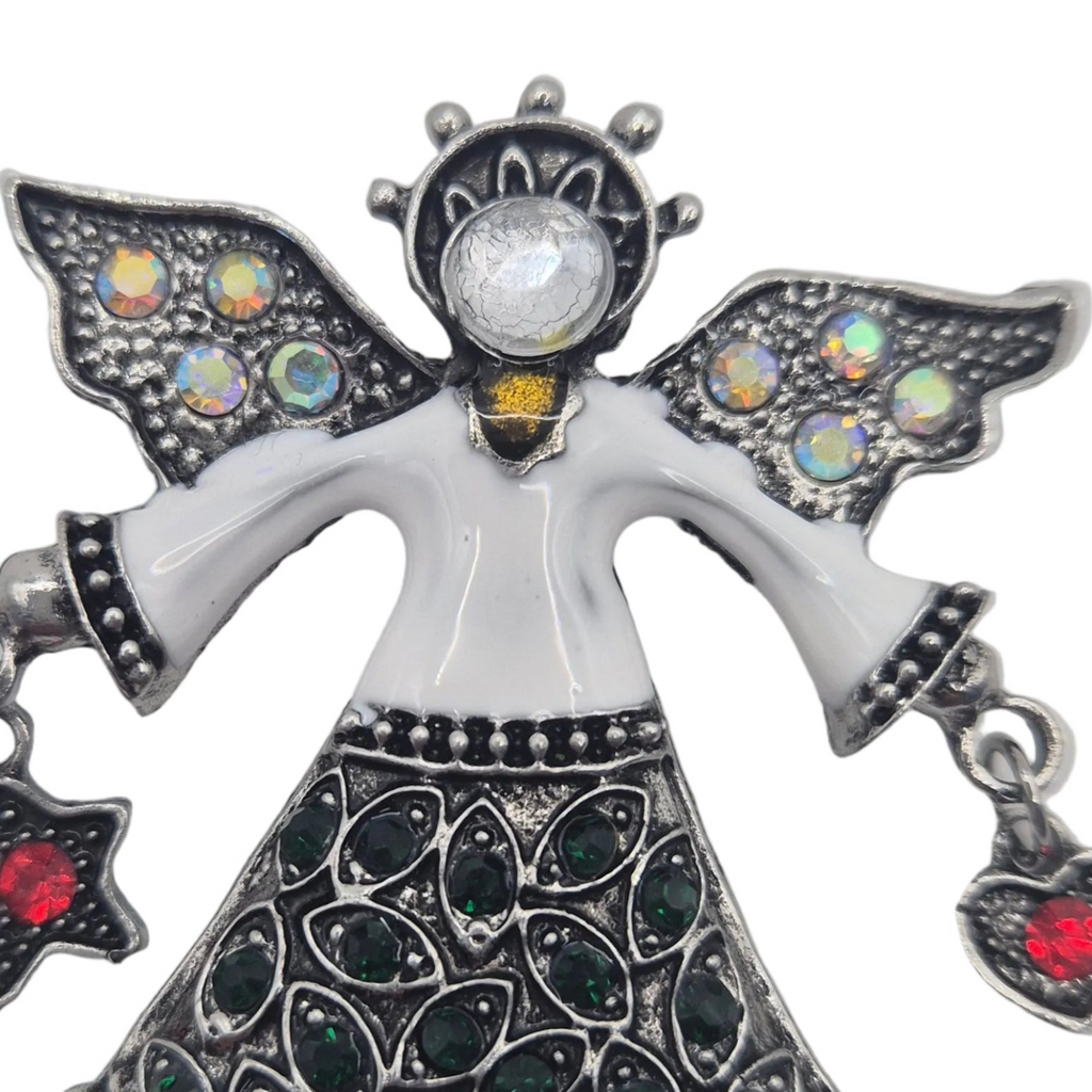 Silver angel pendant with white enamel body, iridescent gemstone wings, and dark green and red rhinestones on a white background.