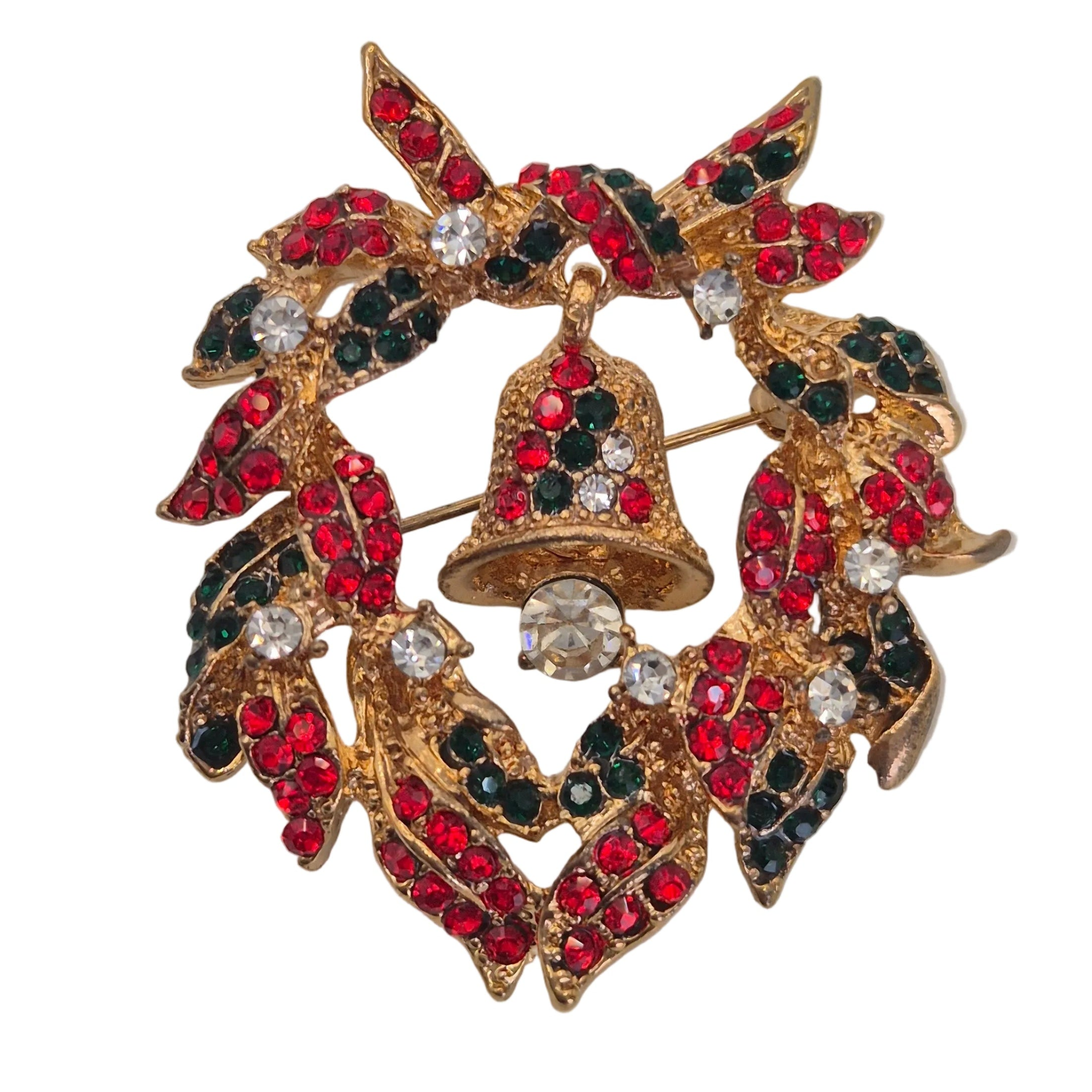 A gold-tone Christmas wreath brooch featuring red and dark green rhinestones, with a central gold bell embellished with red, green, and clear rhinestones, set against a plain white background.