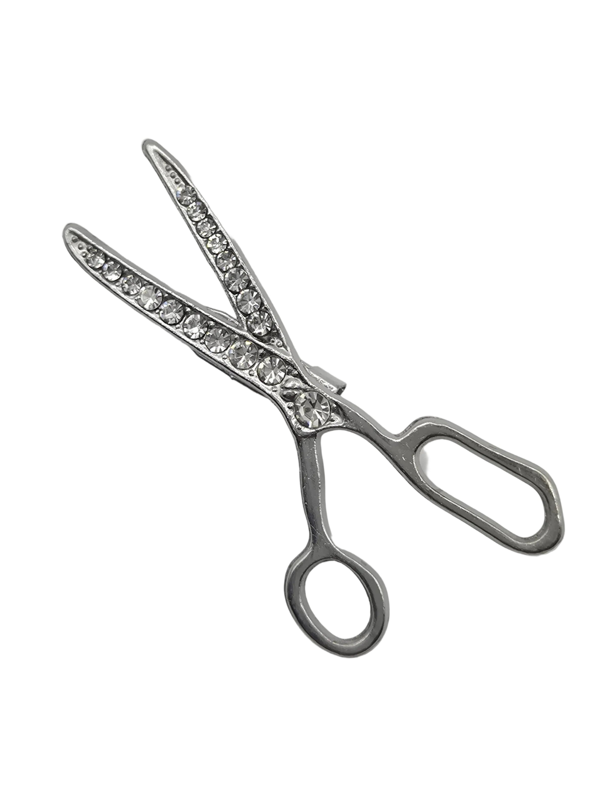 Silver scissors brooch with gemstones on a white background