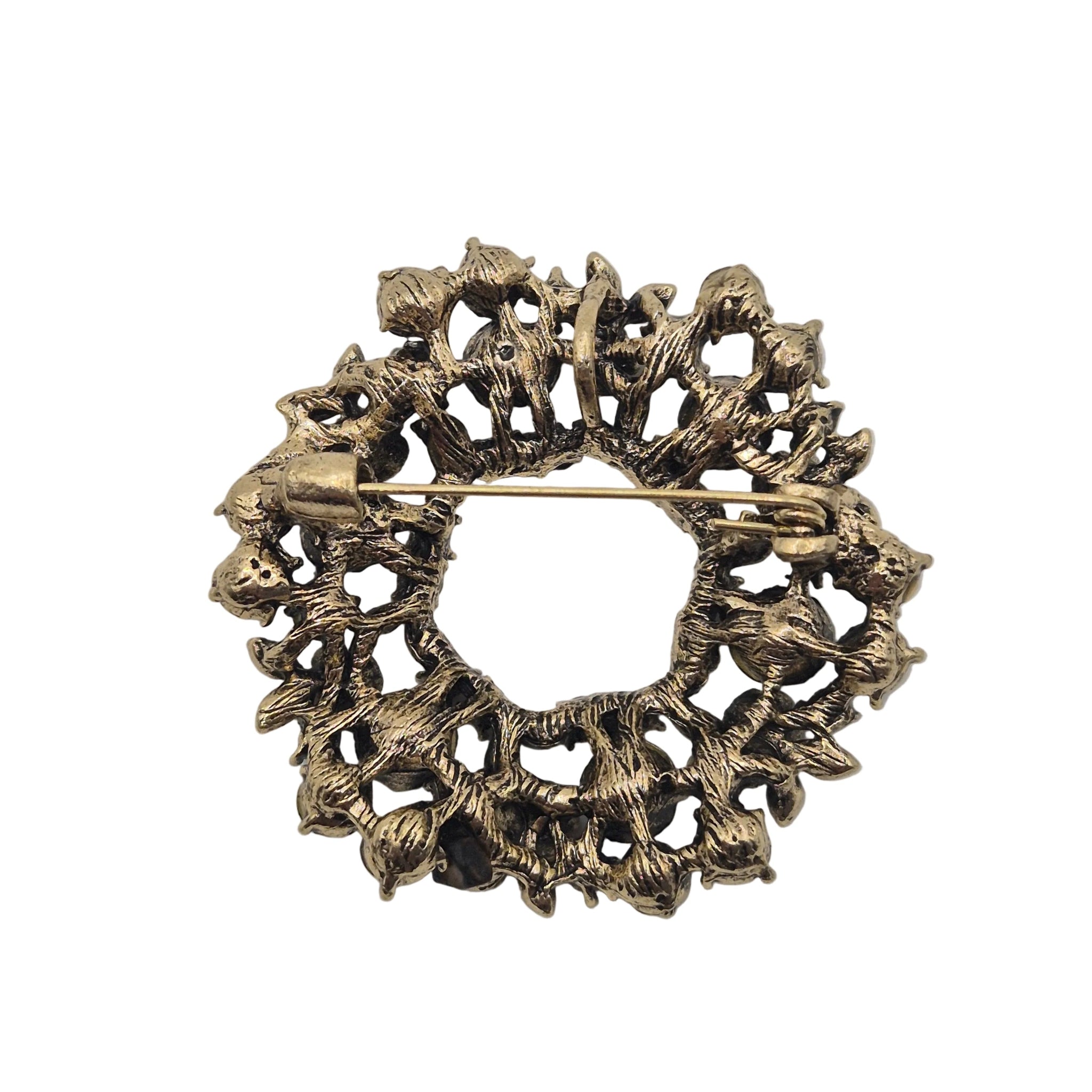 An antique bronze brooch featuring a detailed, textured floral or vine-like openwork design with a pin fastener visible on the back, set against a plain white background.