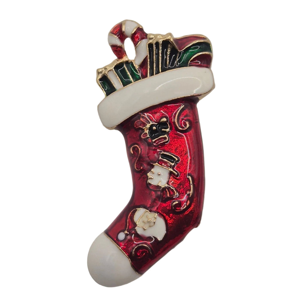 A Christmas stocking brooch with a glossy red body, white cuff and toe, and small gold, green, and white holiday details, shown on a plain white background.