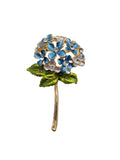 Floral brooch with blue and green details on a light gray background