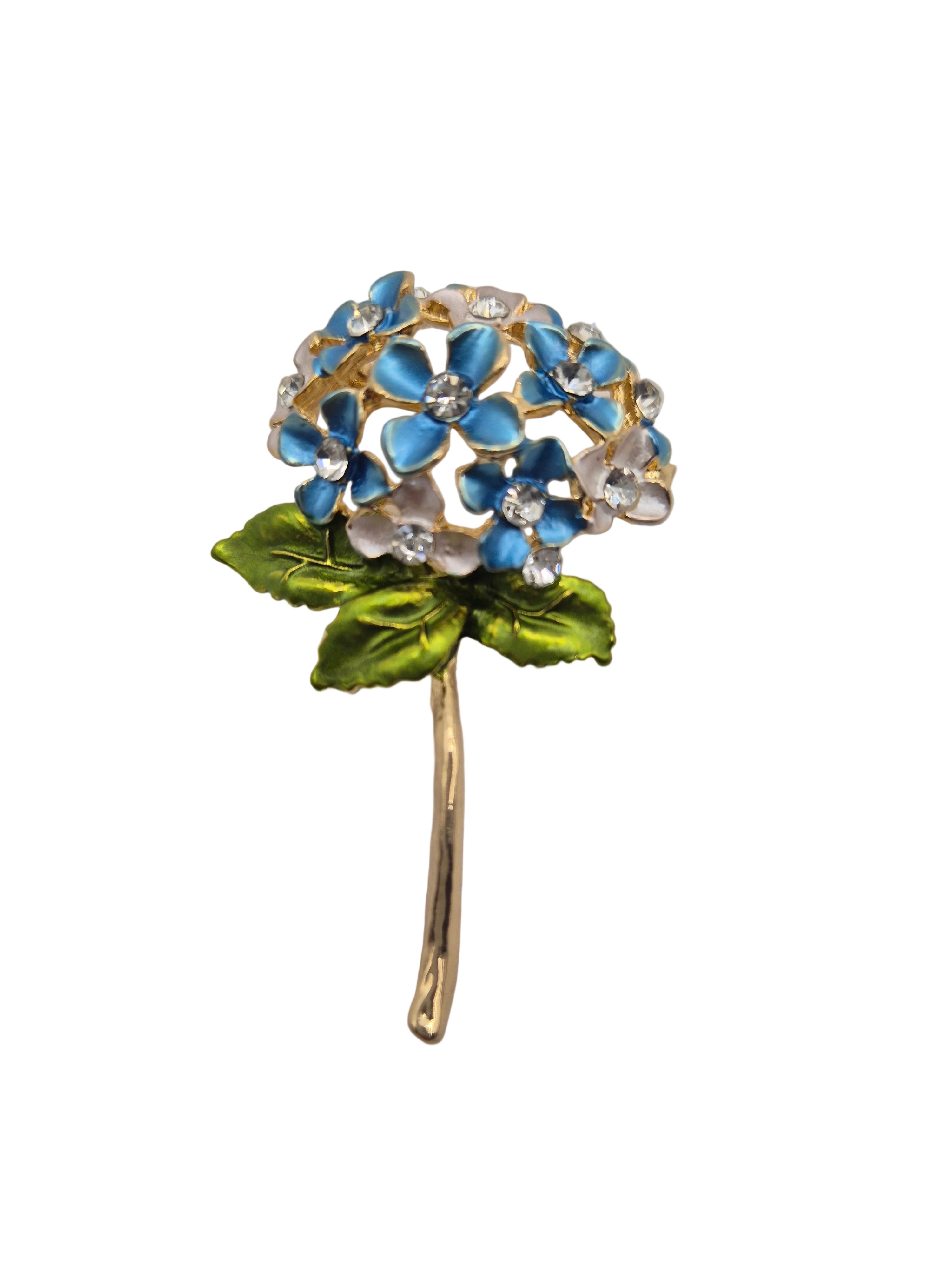Floral brooch with blue and green details on a light gray background