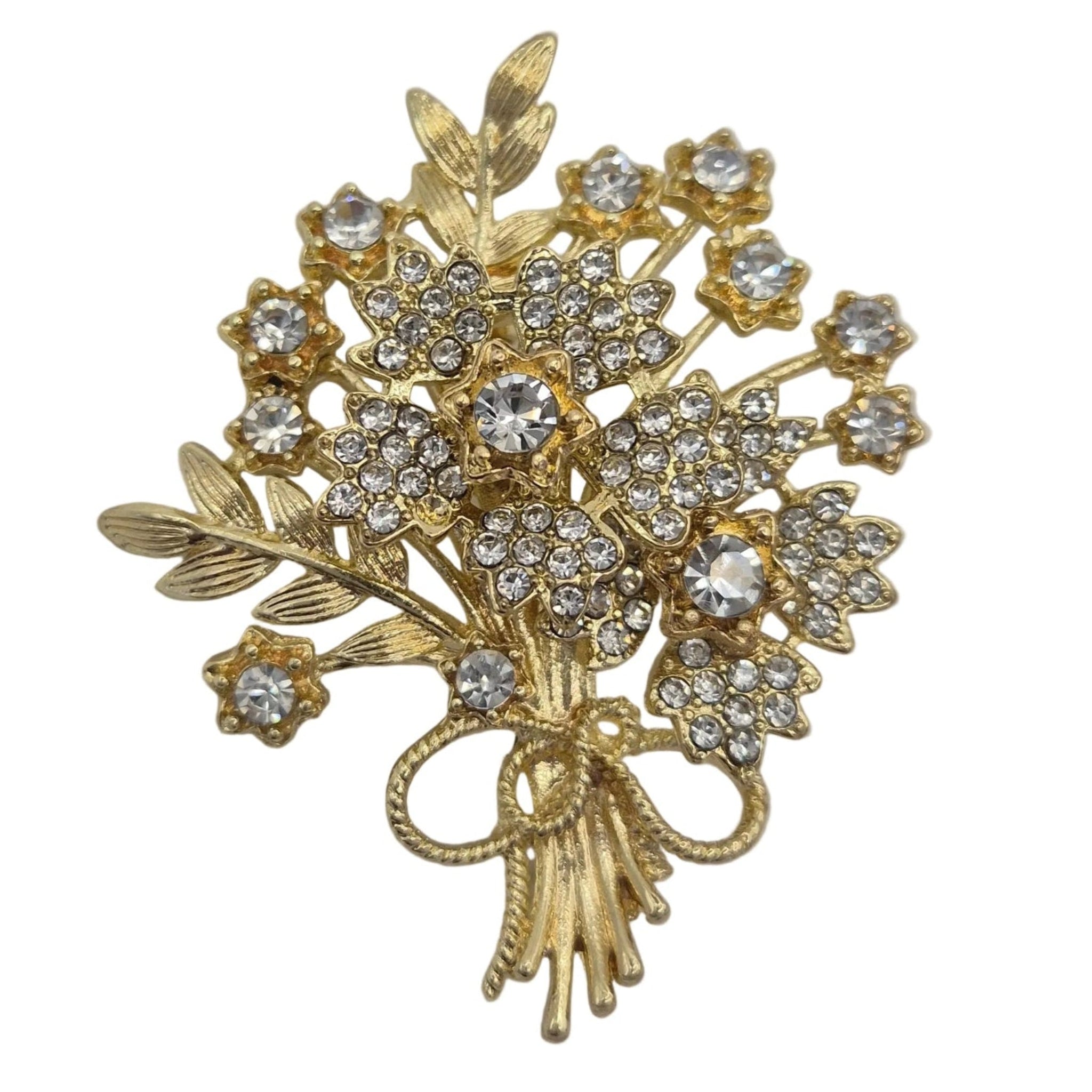 A gold-toned floral bouquet brooch with clear rhinestones, isolated on a white background.