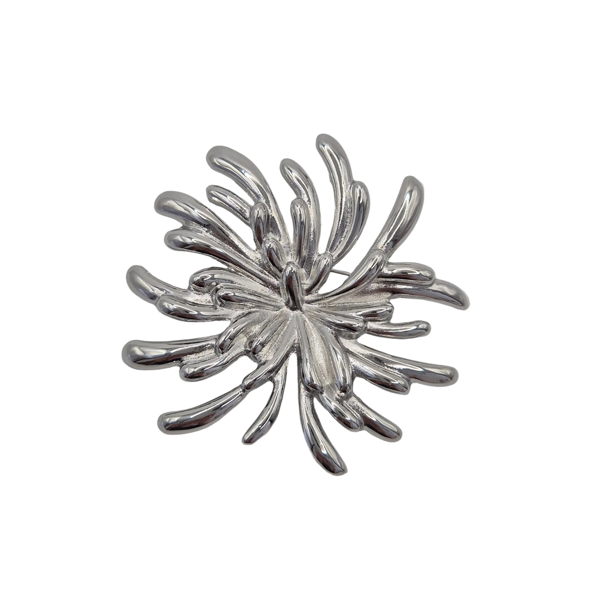 A silver metallic brooch shaped like a stylized firework burst, shown on a plain light gray background.
