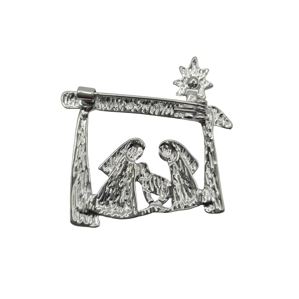 A silver-toned metal Christmas nativity scene ornament featuring Mary, Joseph, baby Jesus, and a star, displayed on a plain white background.