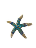 Starfish-shaped jewelry with blue and gold accents on a white background