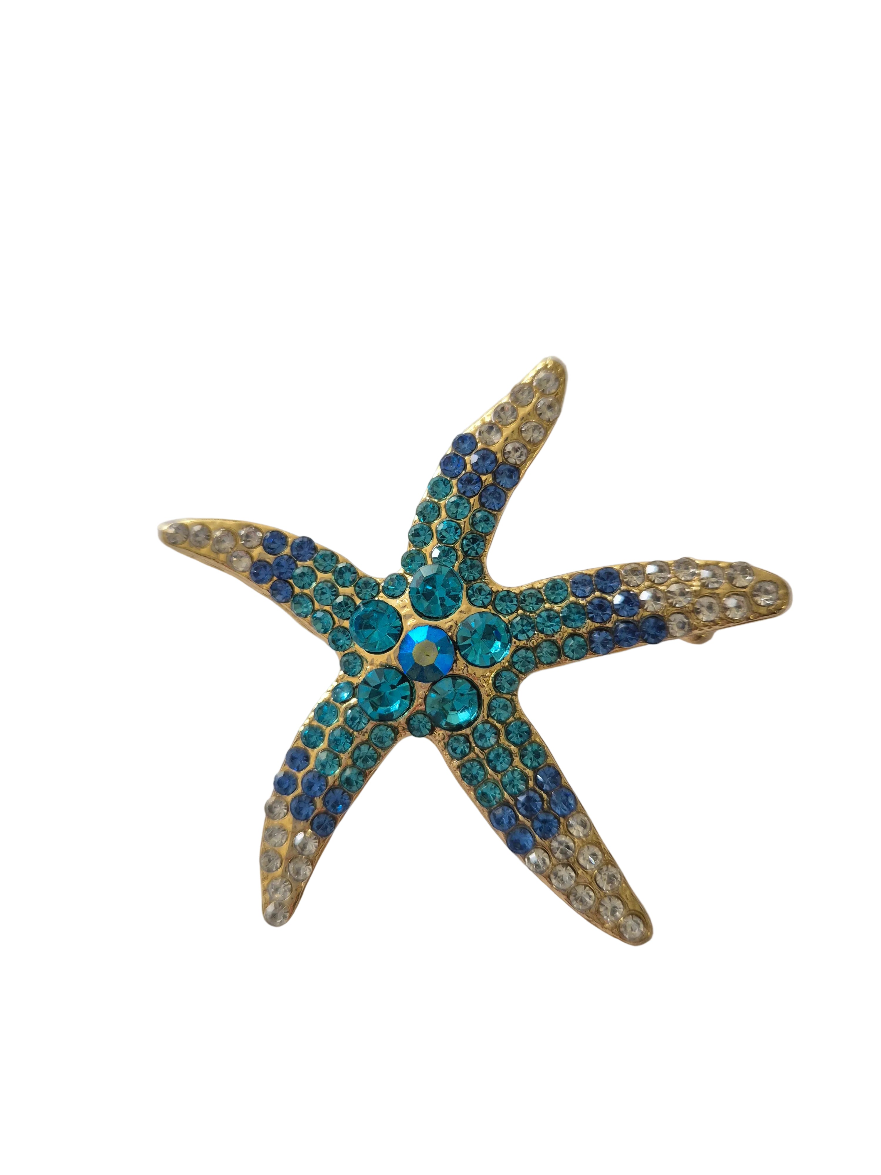 Starfish-shaped jewelry with blue and gold accents on a white background