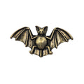 An antique gold tone metal bat pin brooch with spread wings, shown on a plain white background.