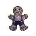 A gingerbread person-shaped brooch or pin with a dark purple enamel body, gold-tone outlines, and rhinestone embellishments in light purple and gold on the head, arms, and legs, shown on a plain white background.