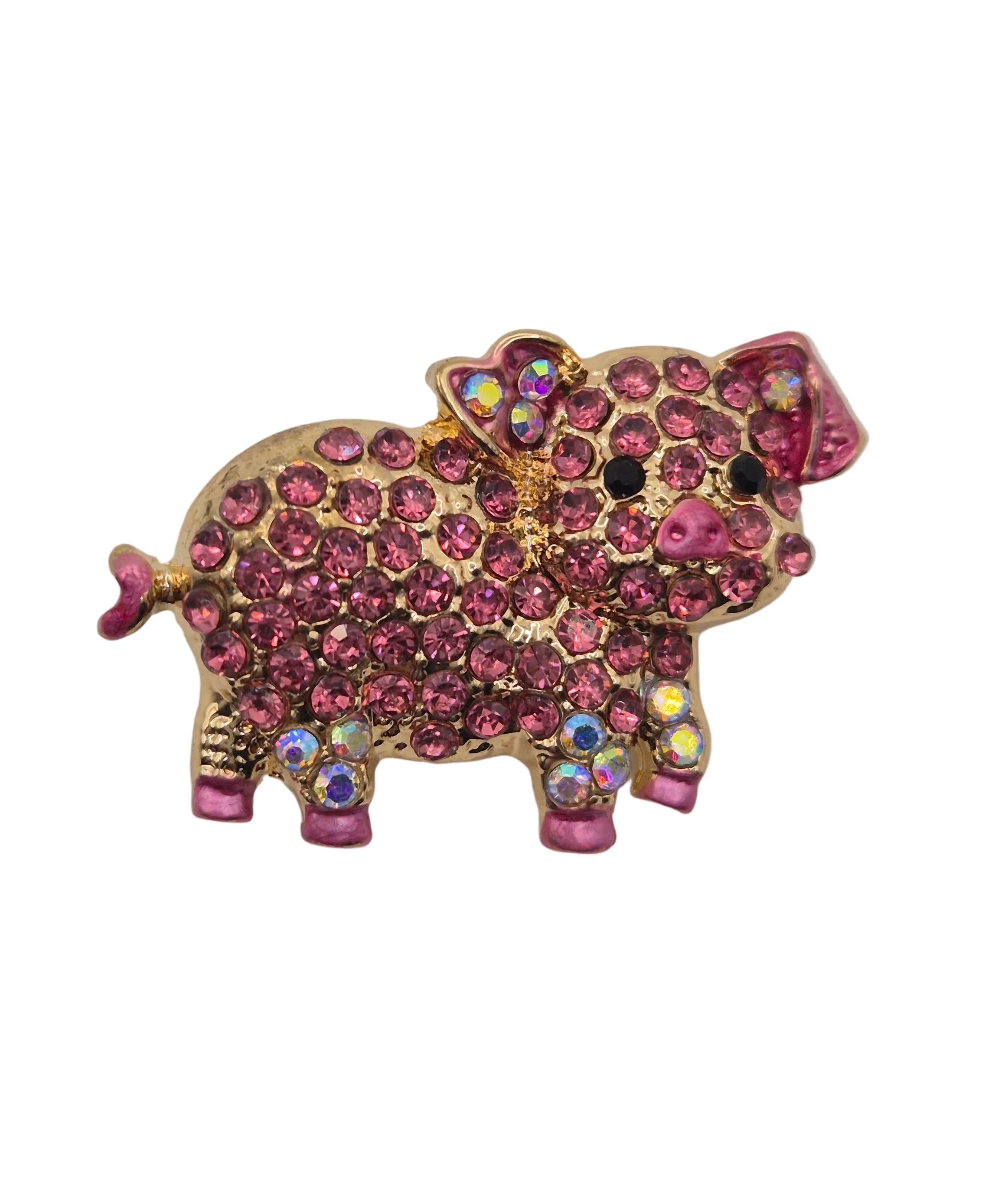 Pig-shaped brooch with pink gemstones on a white background