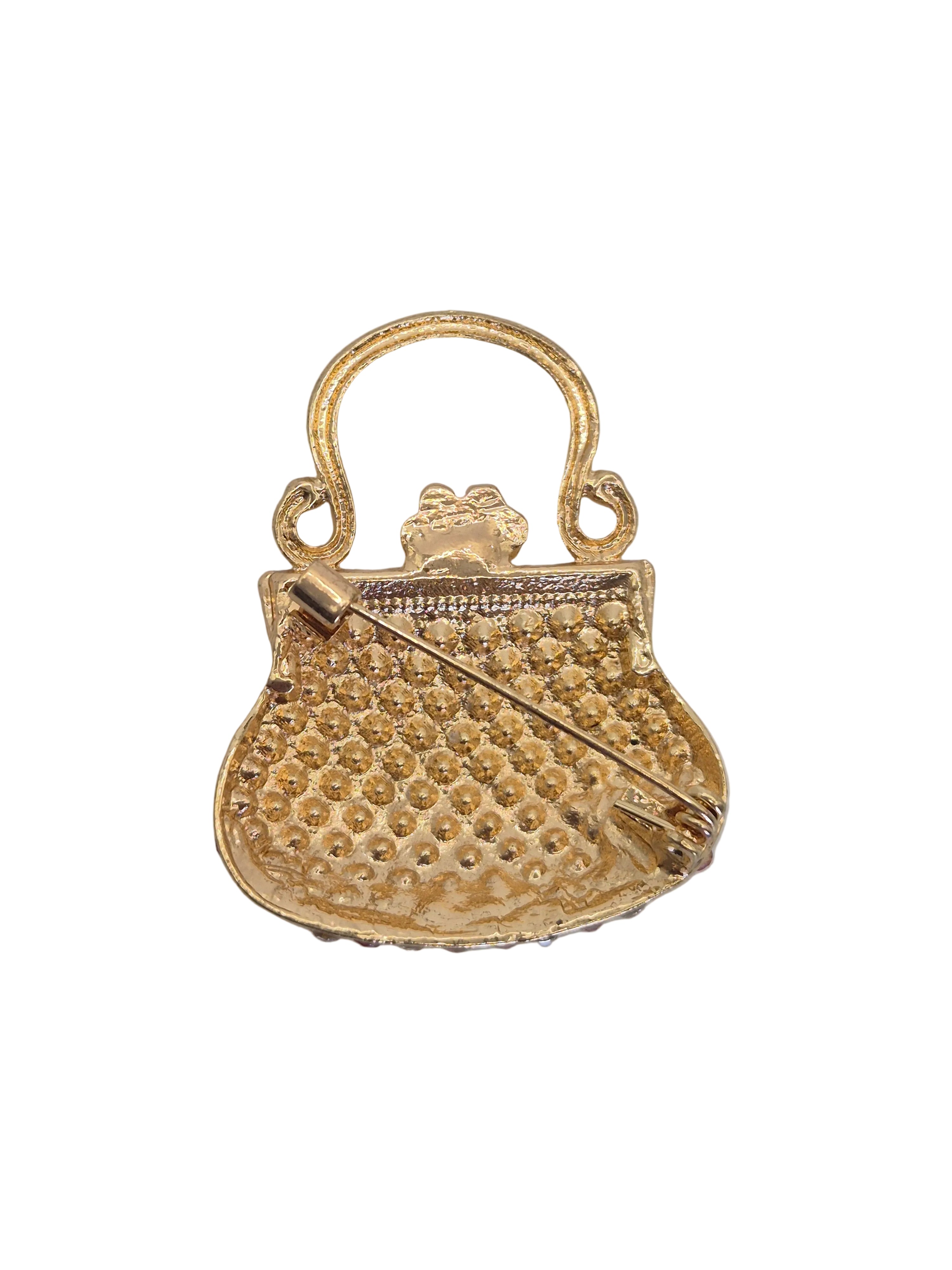 Reverse gold tone side of crystal purse set against plain white background. 
