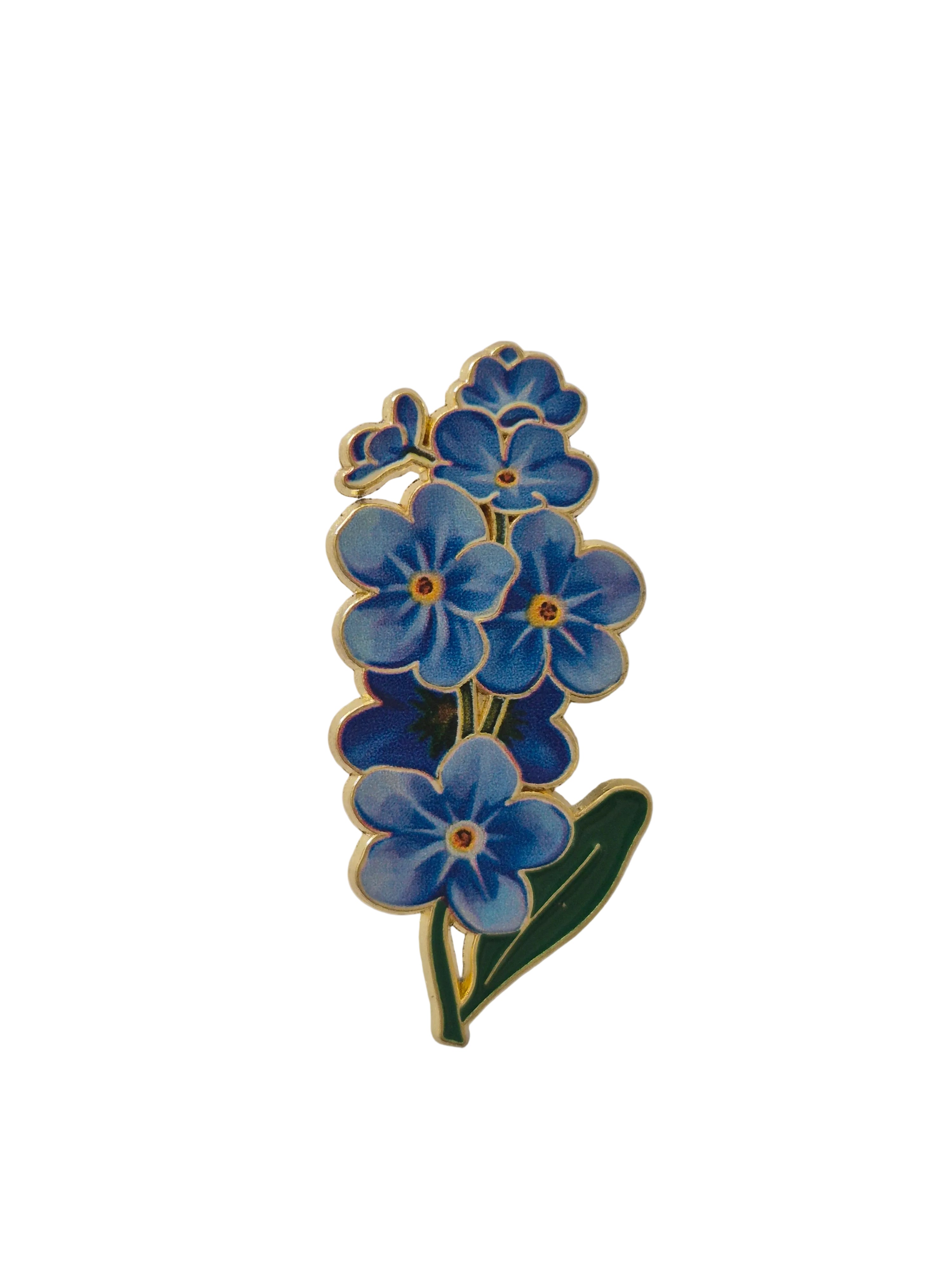 Blue floral brooch with green leaves on a white background