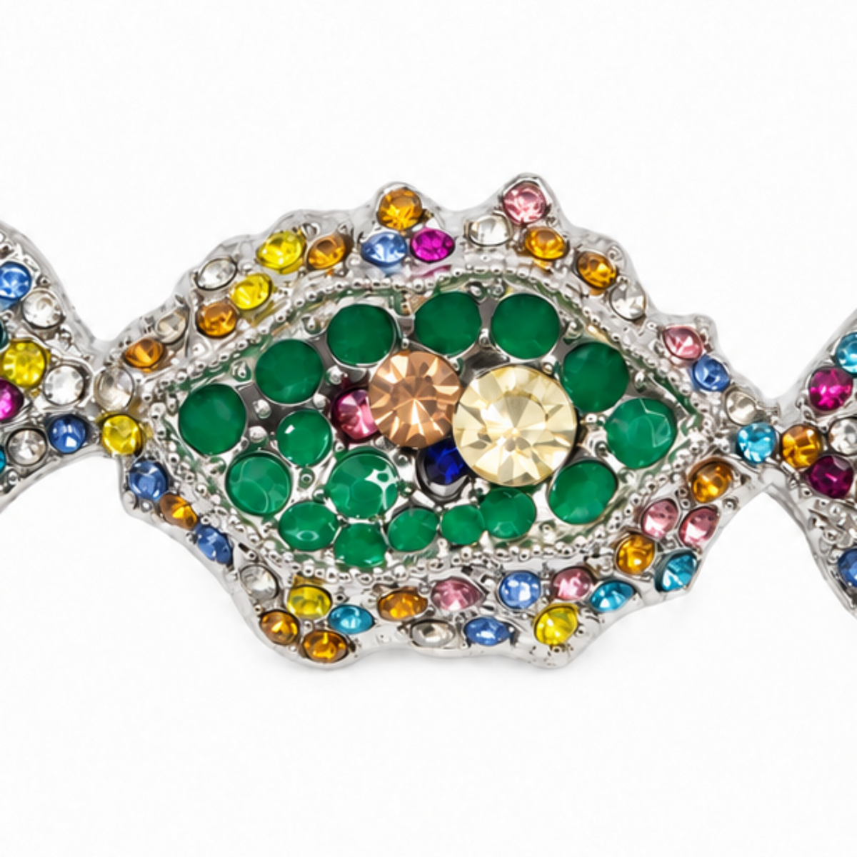 A candy-shaped brooch or pin featuring a silver-tone metal base densely encrusted with multicoloured rhinestones, including green, pink, blue, yellow, and orange, with a central faceted gold crystal.