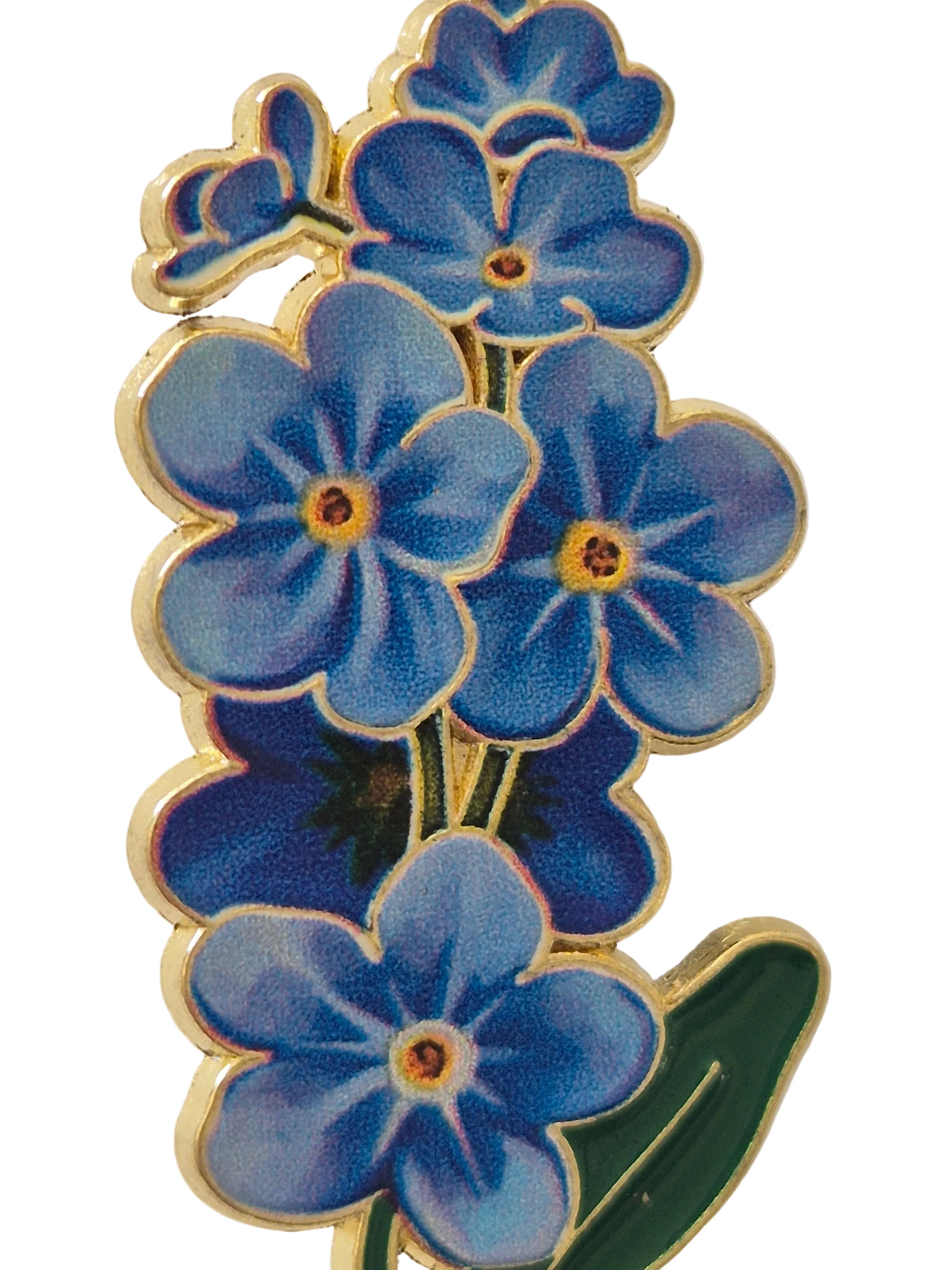 Pin  brooch with blue flowers on a white background