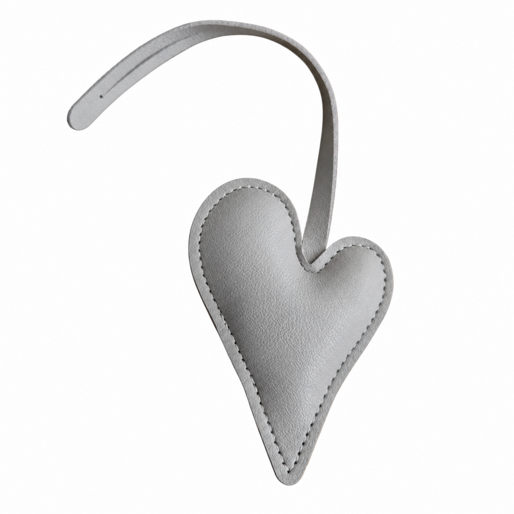 A light gray textured leather heart-shaped bag charm with a matching curved strap, shown on a plain white background.