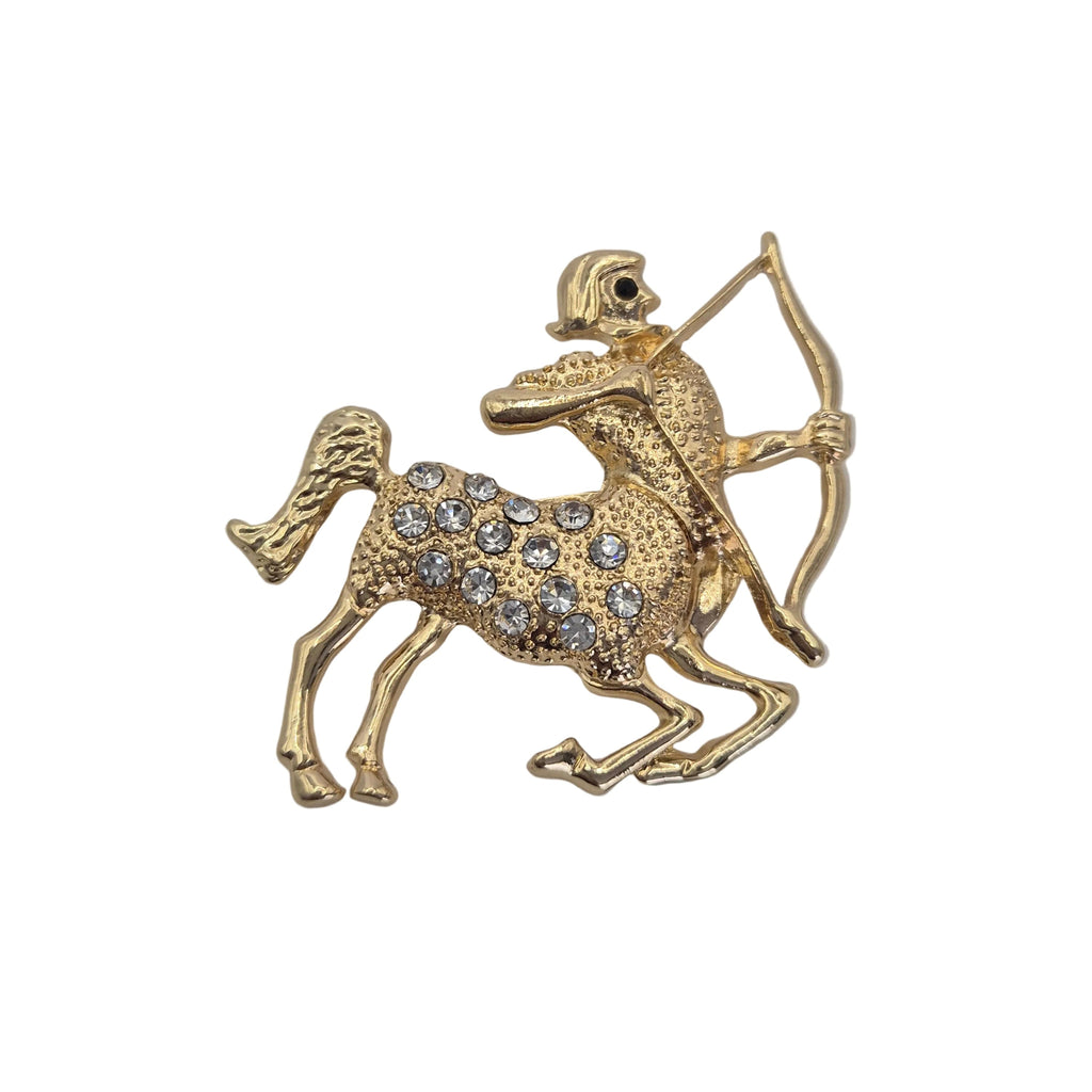 Sagittarius zodiac sign brooch. Gold tone with clear rhinestones. Shown against a plain white background. 