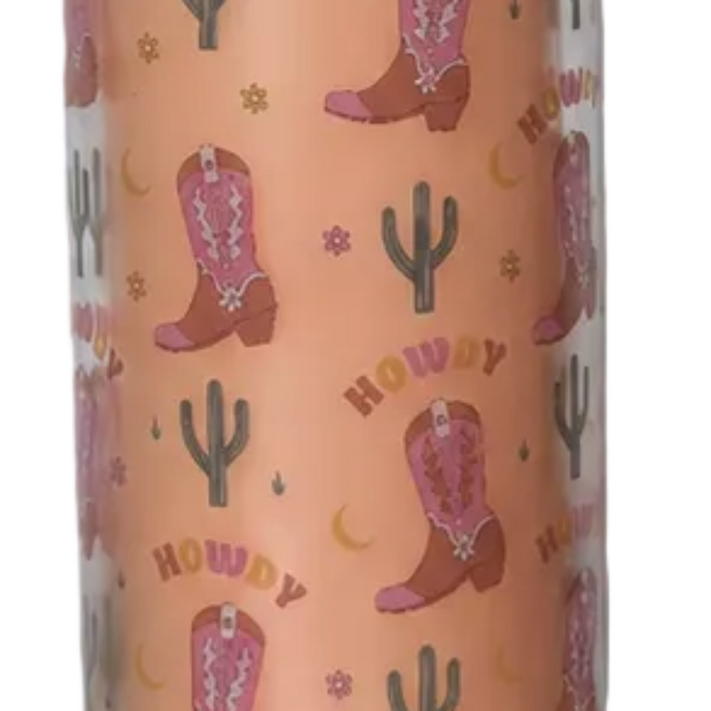 A close-up of a glass tube candle with a repeating western print featuring pink cowboy boots, green cacti, small flowers, and the word 'HOWDY' in yellow.