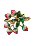 strawberry brooch with green leaves and red berries on a light gray background