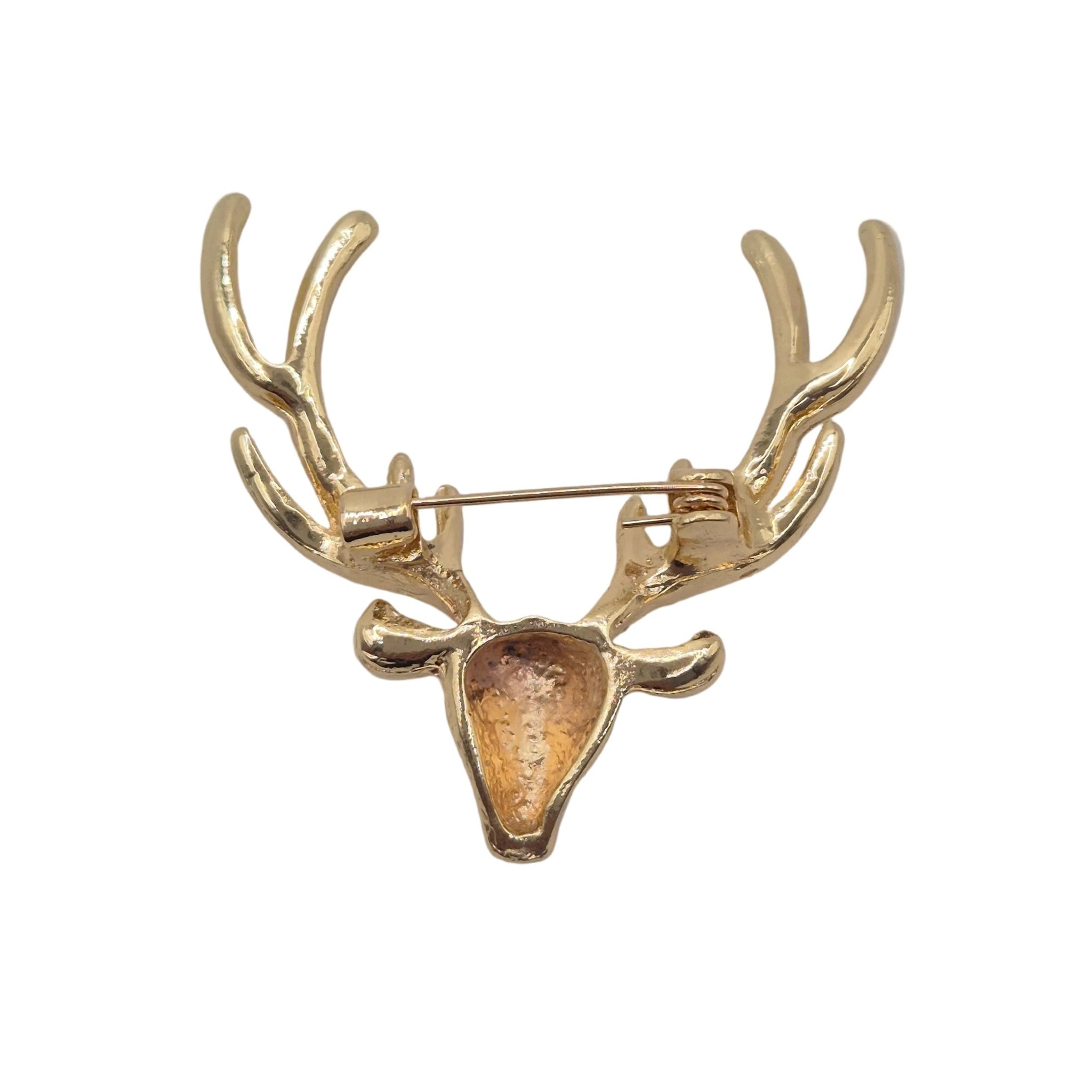 A gold-colored deer head brooch with antlers and a pin back, shown on a plain light gray background.
