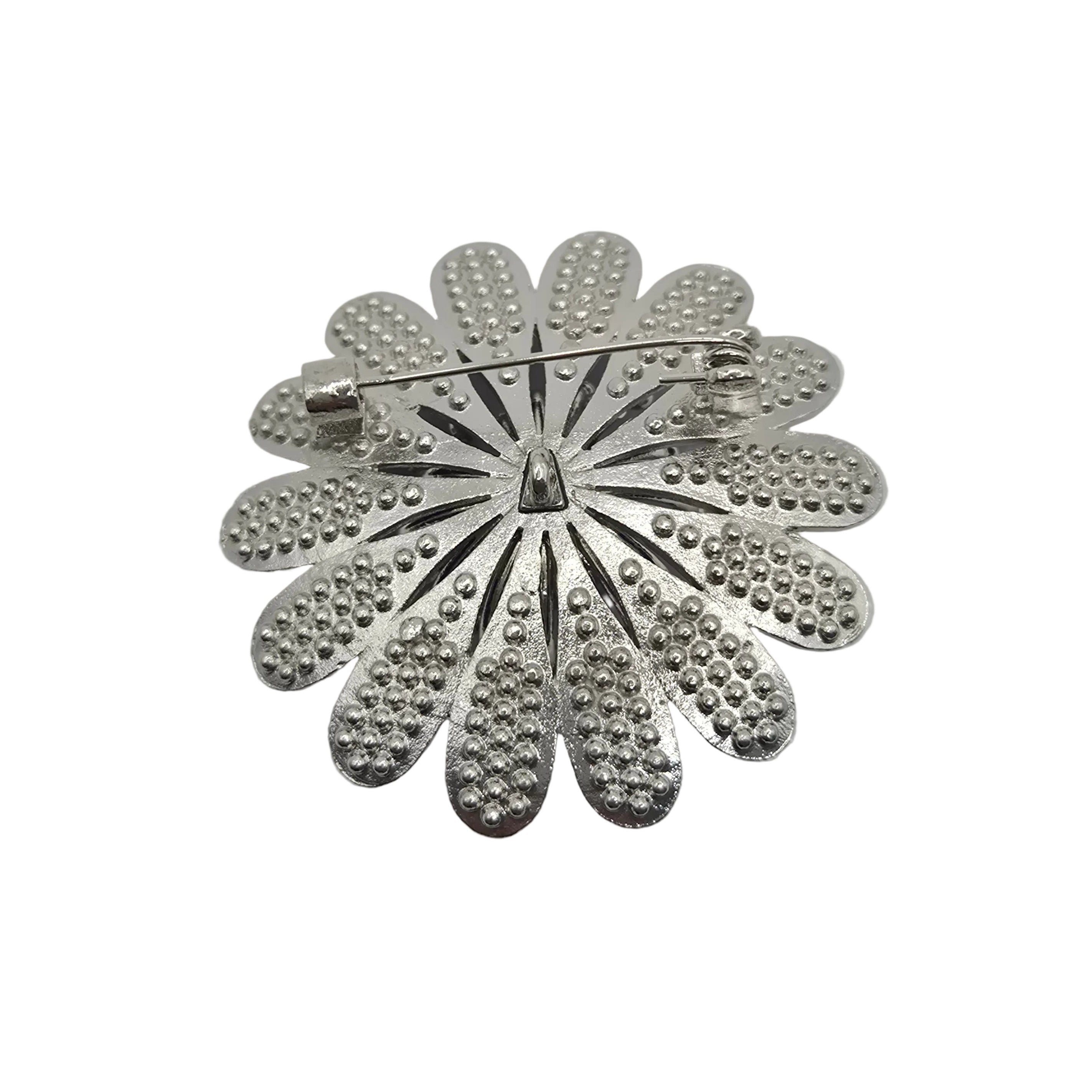 A silver-tone metal flower-shaped brooch with textured petal details and a pin clasp, shown on a plain white background.