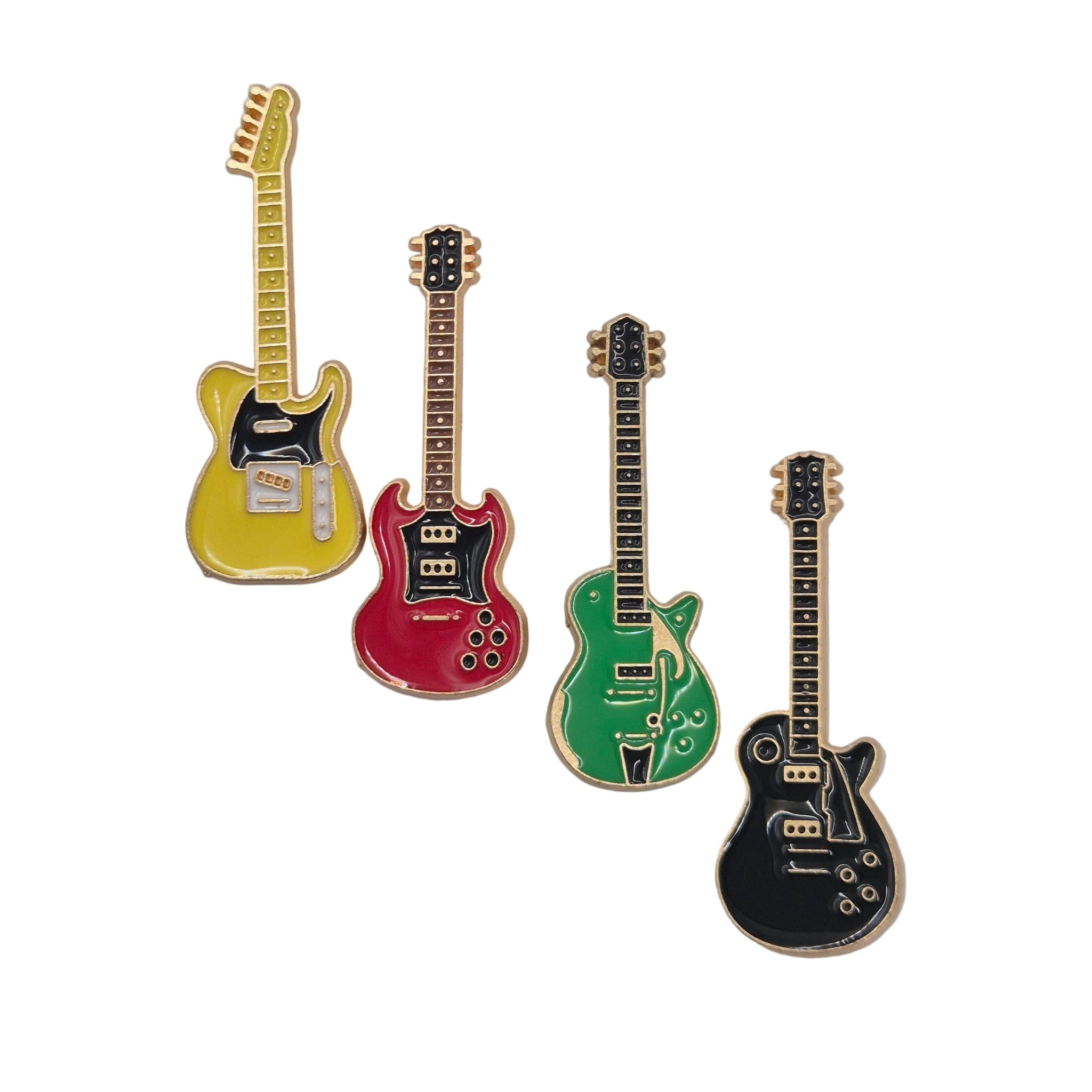 Four guitar-shaped enamel pins in yellow, red, green, and black, arranged diagonally on a white background.