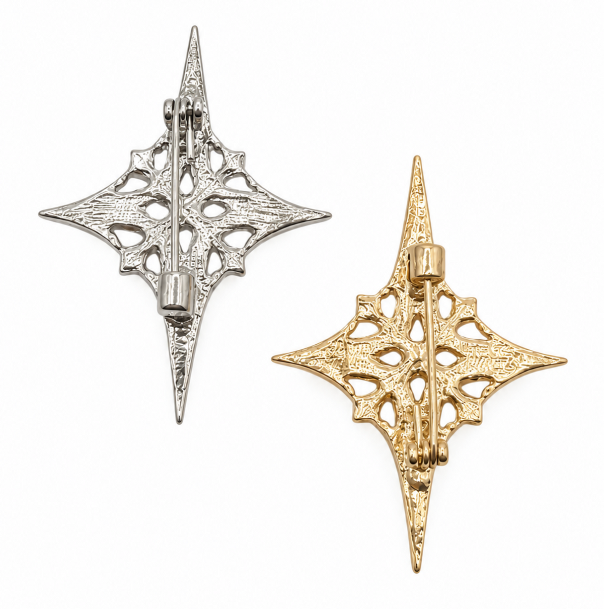 Two ornate star-shaped brooches with filigree cutouts and pin-back fasteners, shown on a plain white background. One is silver-toned and the other is gold-toned.