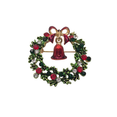 A Christmas wreath brooch with a gold-tone metal base, decorated with green holly leaves, red berries, clear rhinestones, and a central red bell with a red bow at the top.