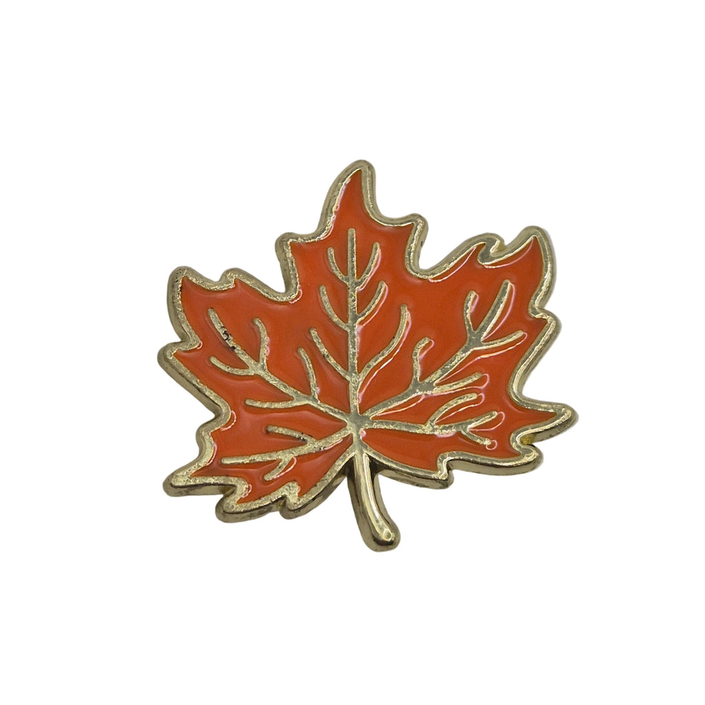 An orange-red maple leaf enamel pin with a gold-toned metal outline and vein detailing, shown on a plain white background.