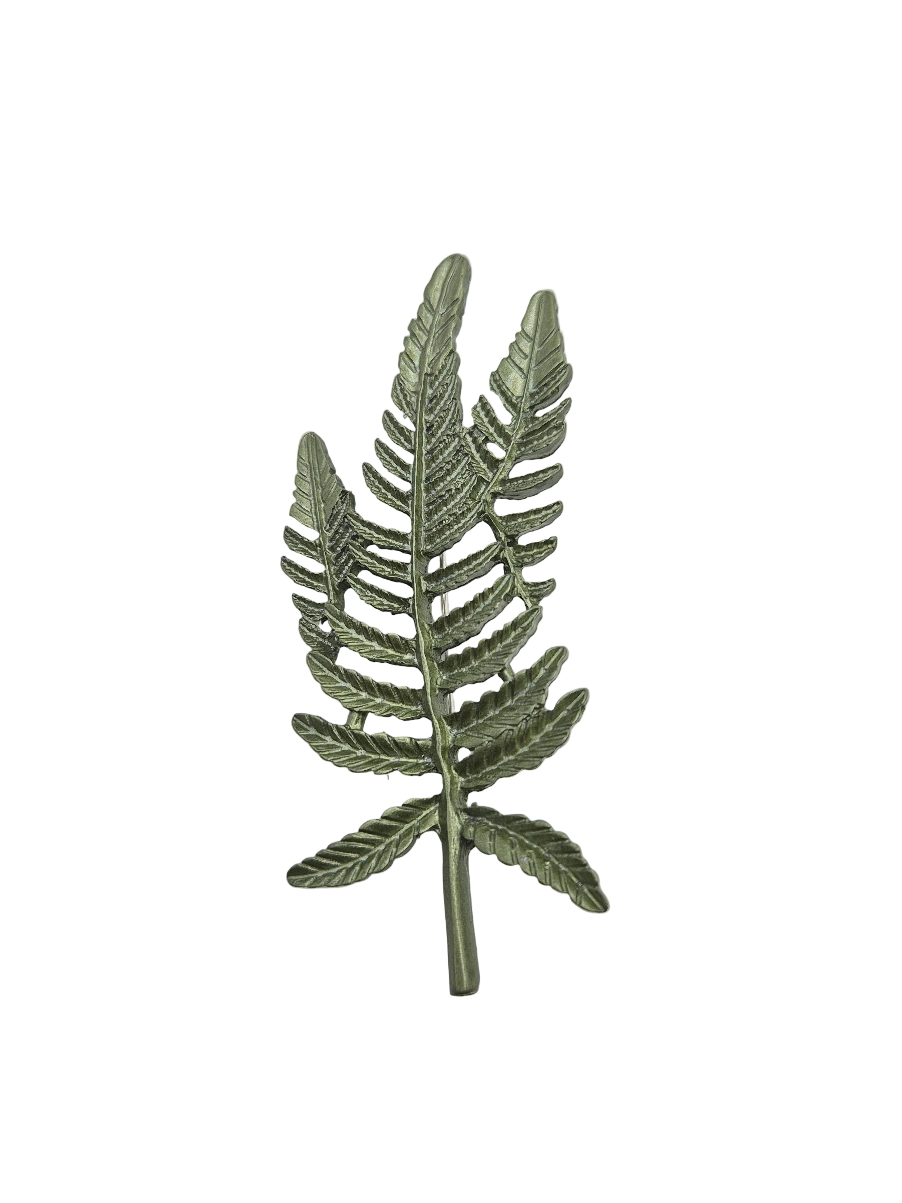 Green fern leaf brooch on a plain white background. 