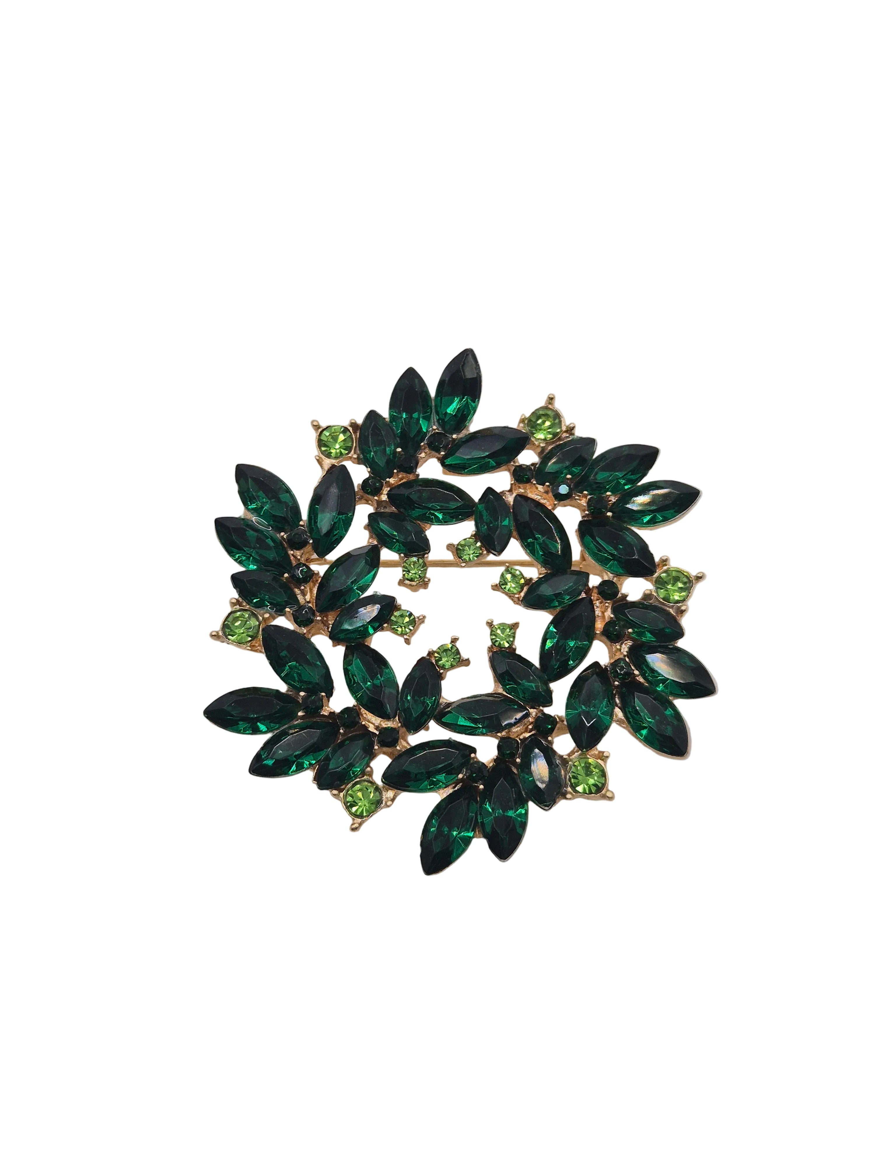Green gemstone brooch on a gray background
