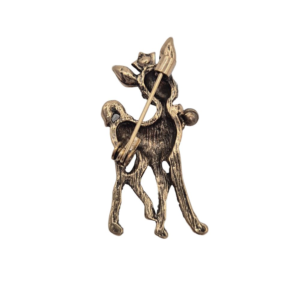 A vintage-style bronze-toned metal brooch depicting a stylized deer holding a bow, shown on a plain white background.