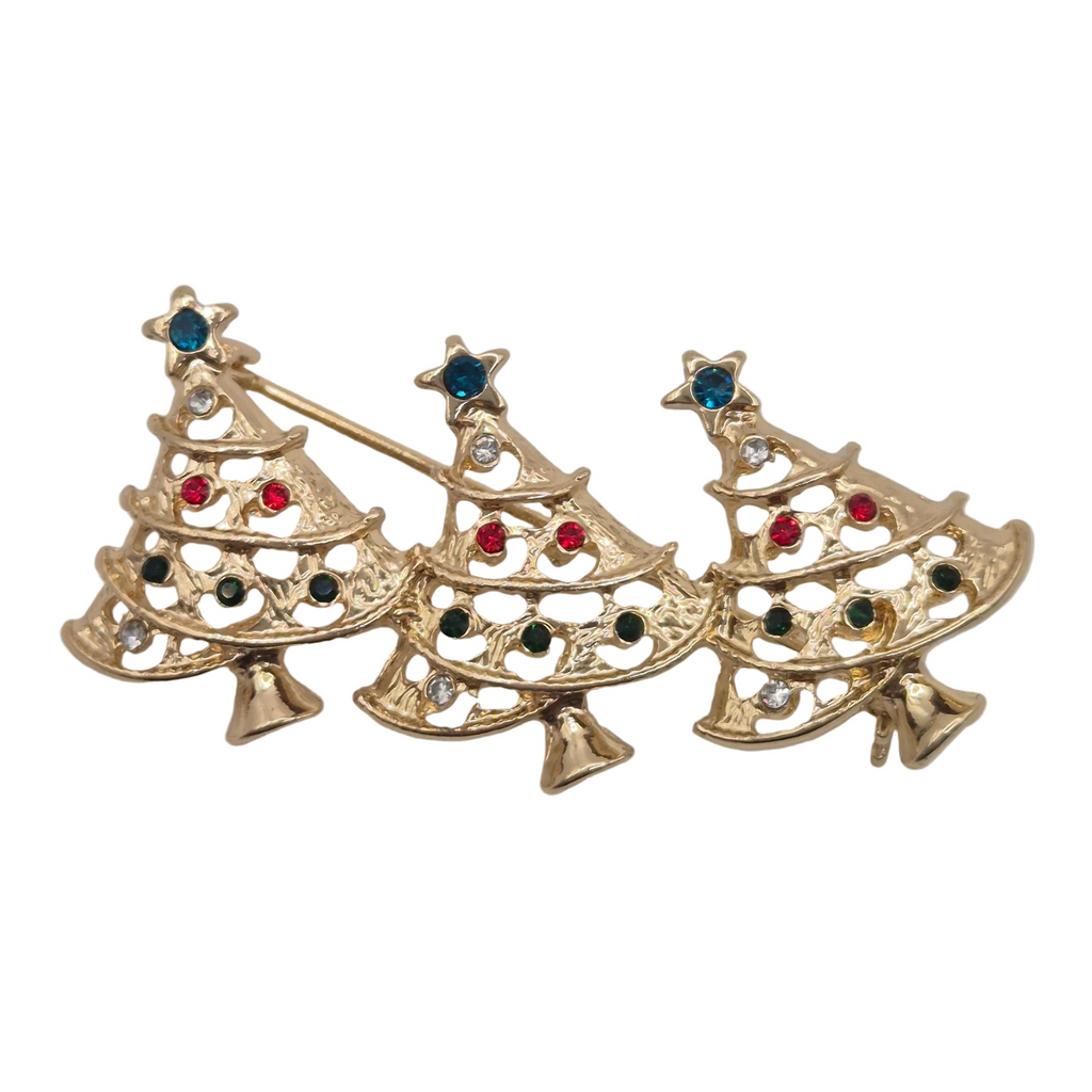 A gold-tone Christmas tree brooch with three overlapping tree shapes, decorated with small red, blue, black, and clear rhinestones, shown on a plain white background.
