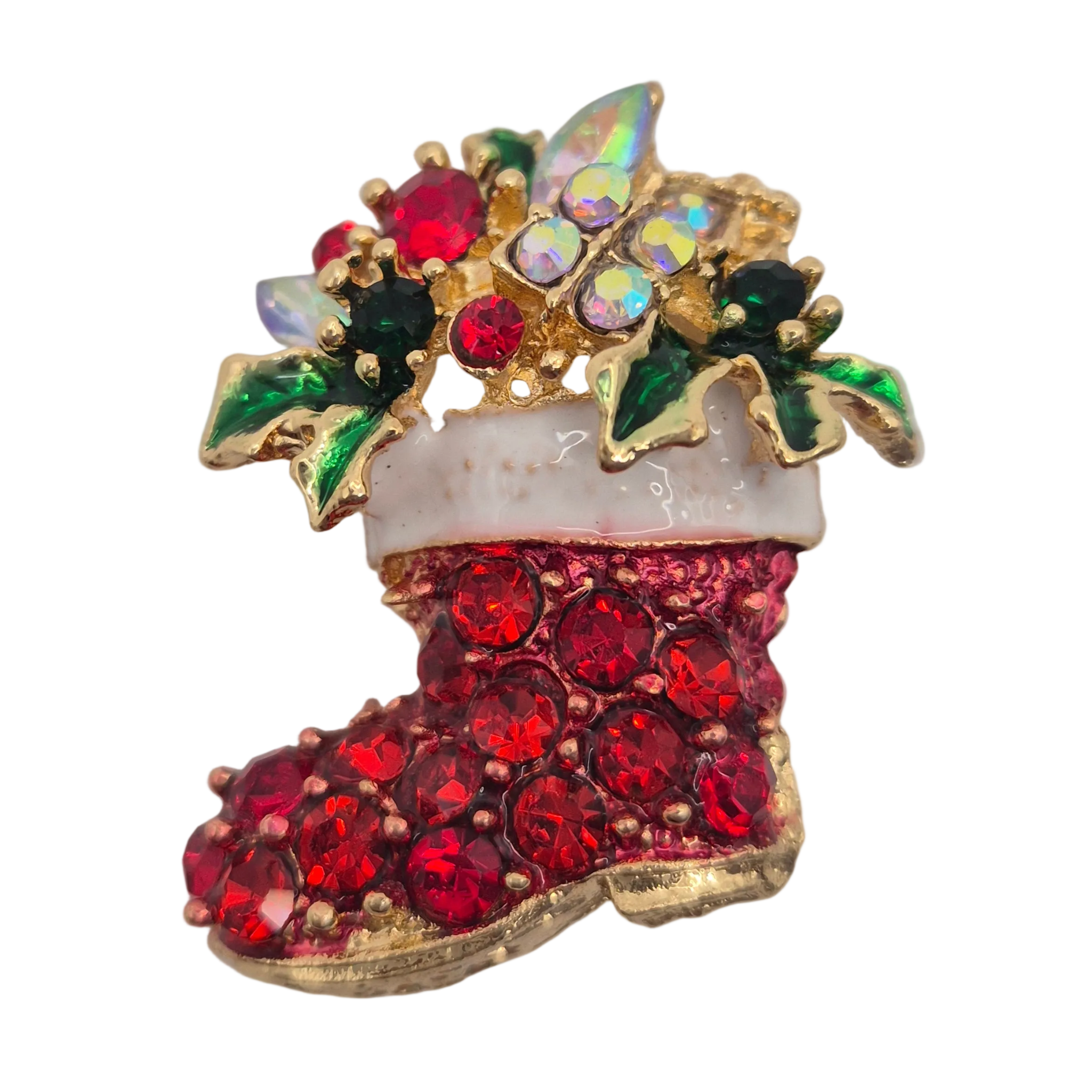 A Christmas stocking brooch featuring red rhinestones on the boot, a white faux-fur cuff, green and iridescent crystal holly leaves, and gold-tone metal outlines, shown on a plain white background.