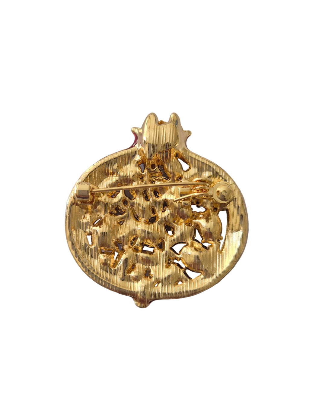 Pomegranate brooch with red gemstones and gold accents on a white background