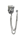 Silver-tone lion head brooch with a rhinestone detail crown, attached to a double chain with a rhinestone bead, on a white background.