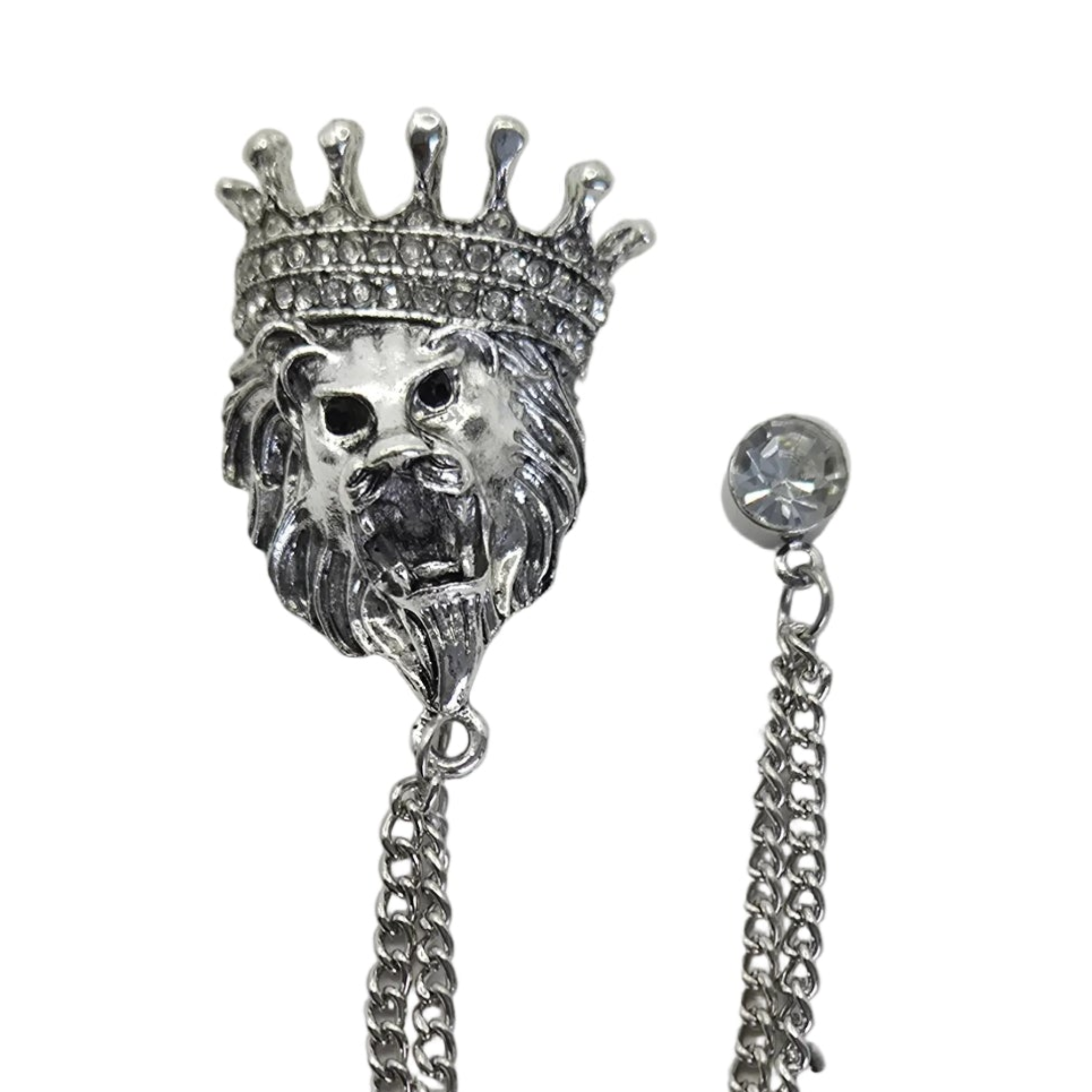 Silver-tone lion head brooch with a crown and dangling chain, shown on a plain white background with a close-up of the rhinestone-studded crown and chain end.