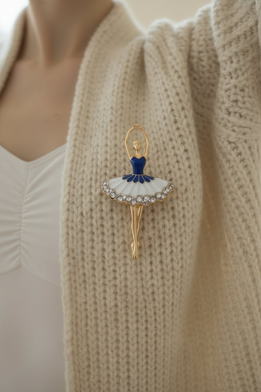 dancing figure brooch with rhinestone detail on plain background