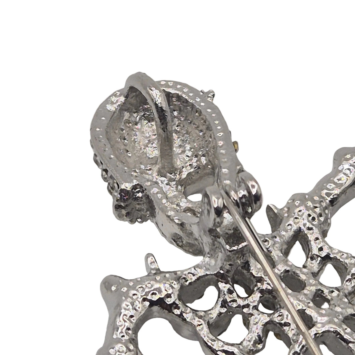 Close-up of a silver-toned skeleton brooch with a pin fastener visible, photographed on a plain white background.