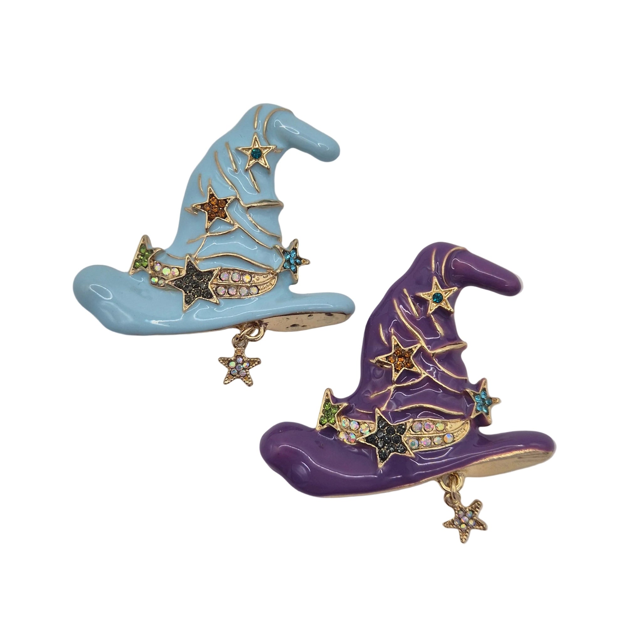 Two wizard or witches hat brooch pins on a white background, one in light blue and one in purple, both with gold-tone metal trim, star details, and small rhinestone accents.