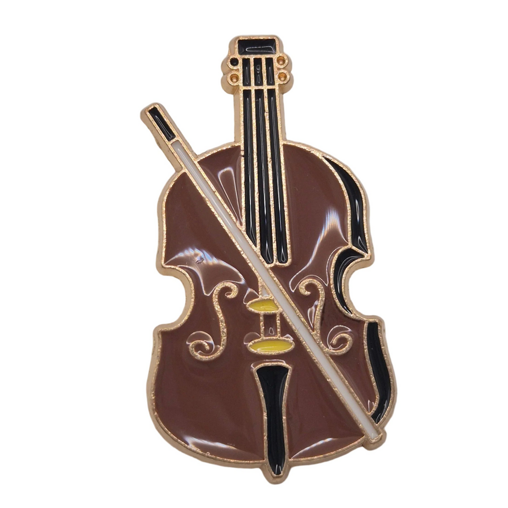 A violin-shaped enamel pin with a glossy brown body and neck, gold metal outlines, and a white bow crossing diagonally across the front, isolated on a white background.